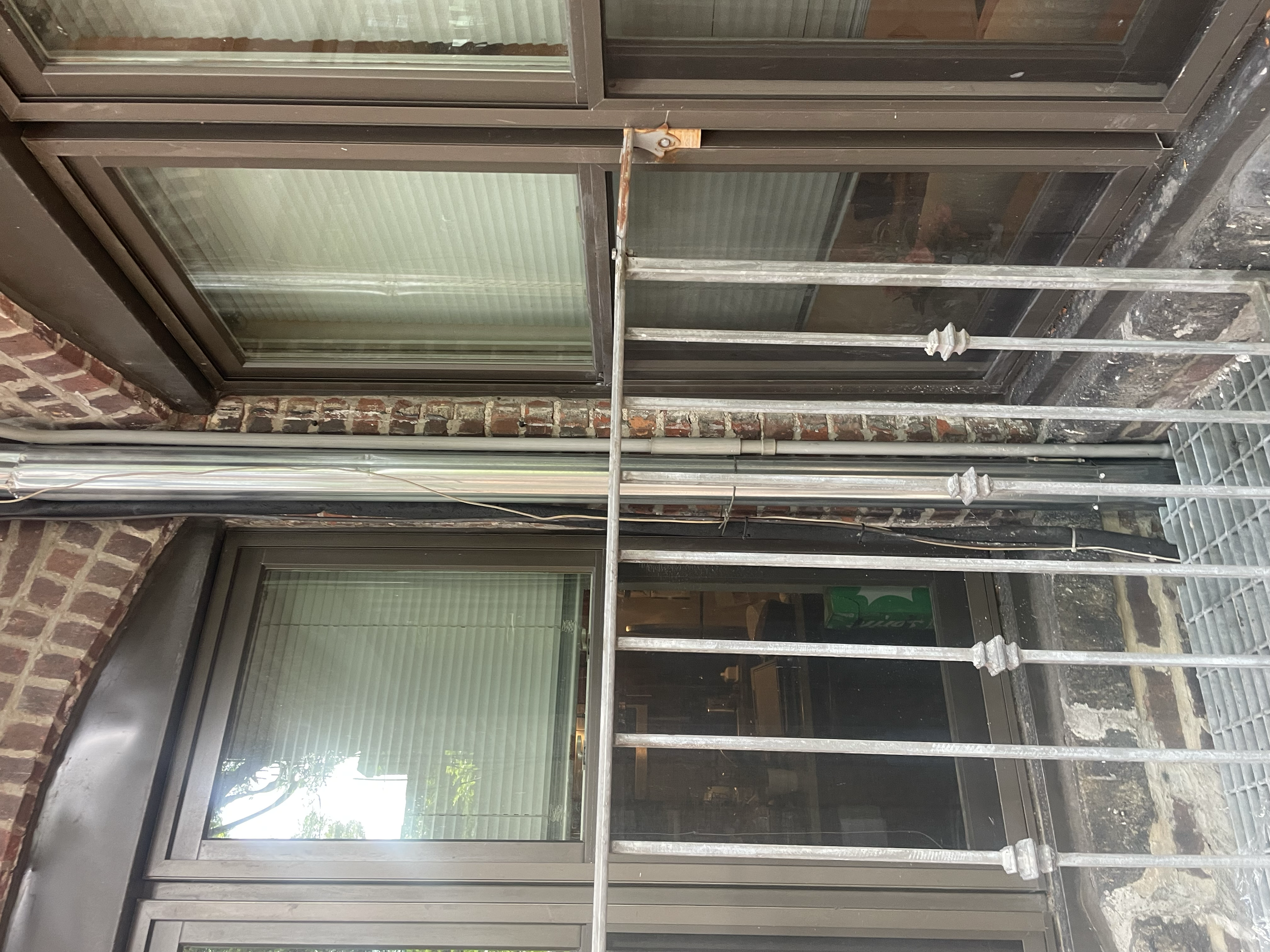 Exterior view of windows with metal bars on a brick building