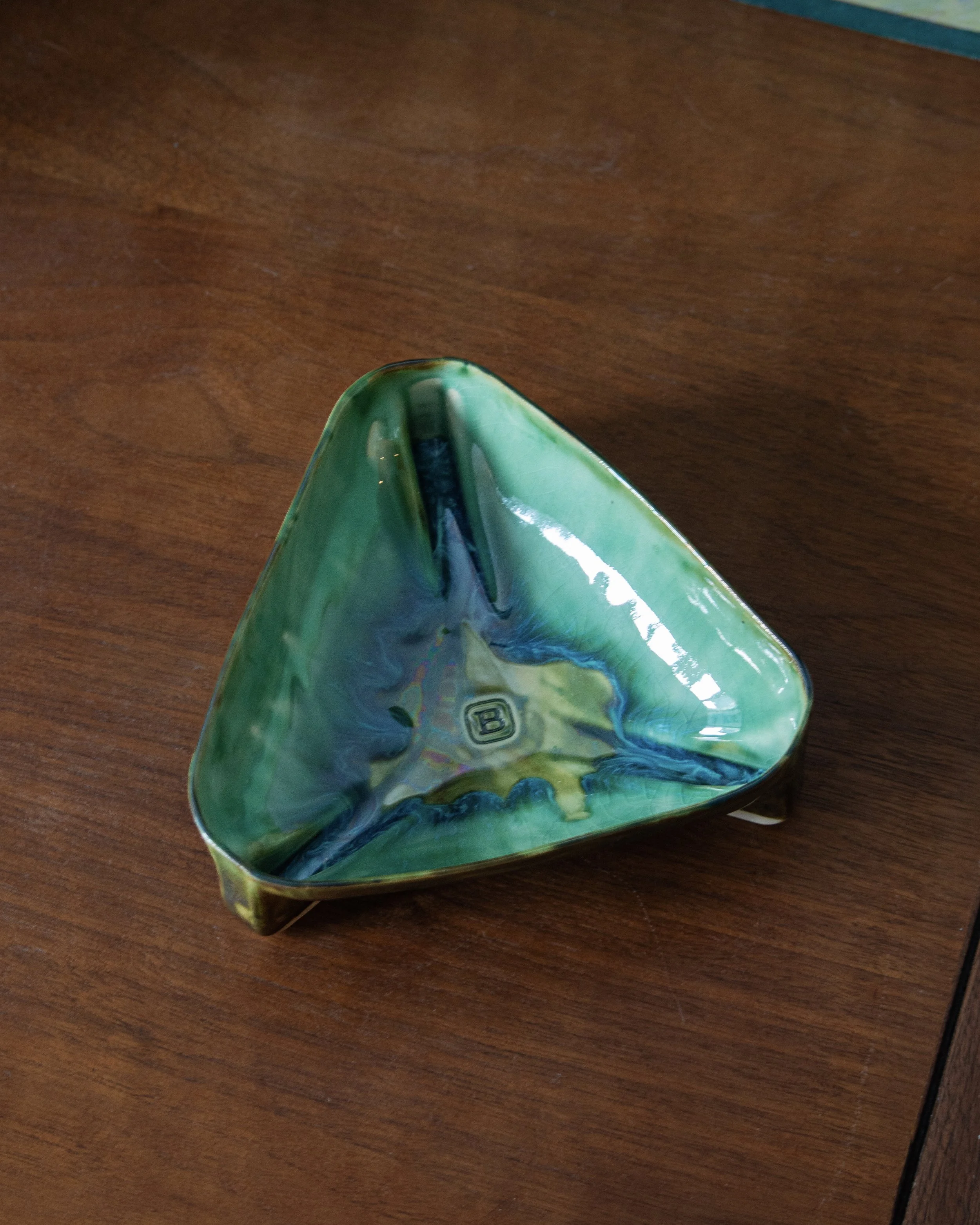 Top view of a triangular handmade ceramic bowl with glossy green and blue glaze