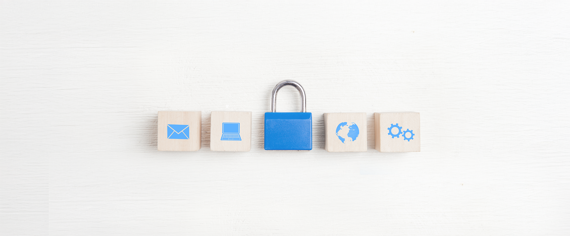 Wooden blocks with icons of an envelope, laptop, blue lock, globe, and gears on a white background.