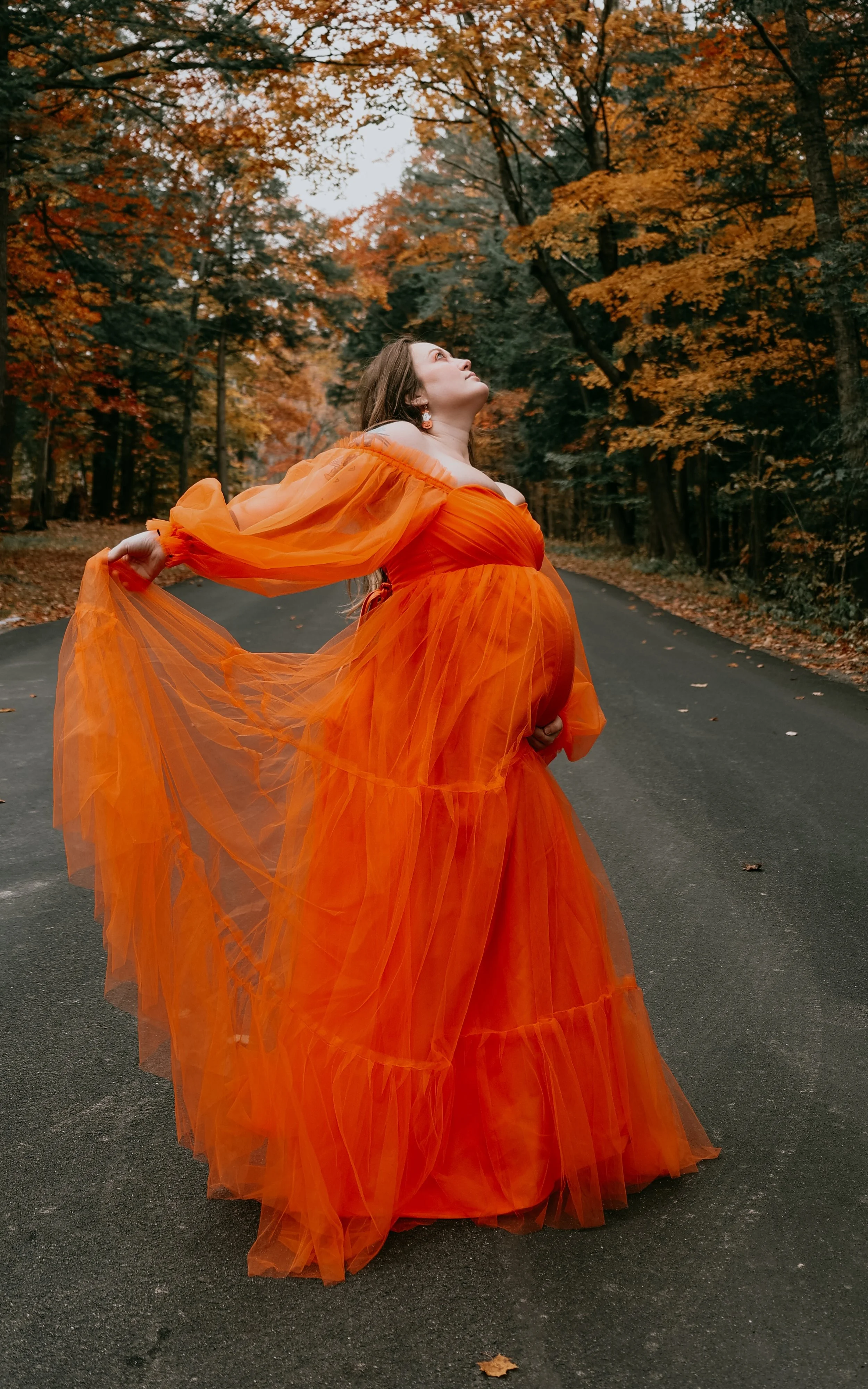 photographer in Buffalo NY capturing a pregnant women in a beautiful orange dress