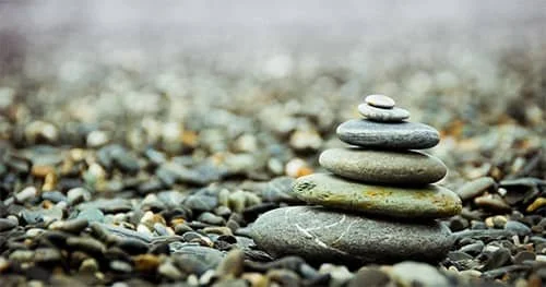 Stacked stones on a quiet pebble surface.