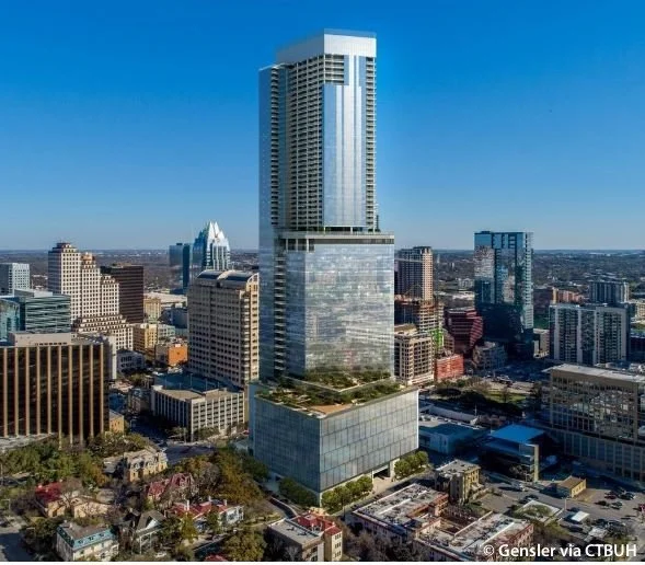 Tall modern skyscraper in a city skyline with other high-rise buildings against a clear blue sky.