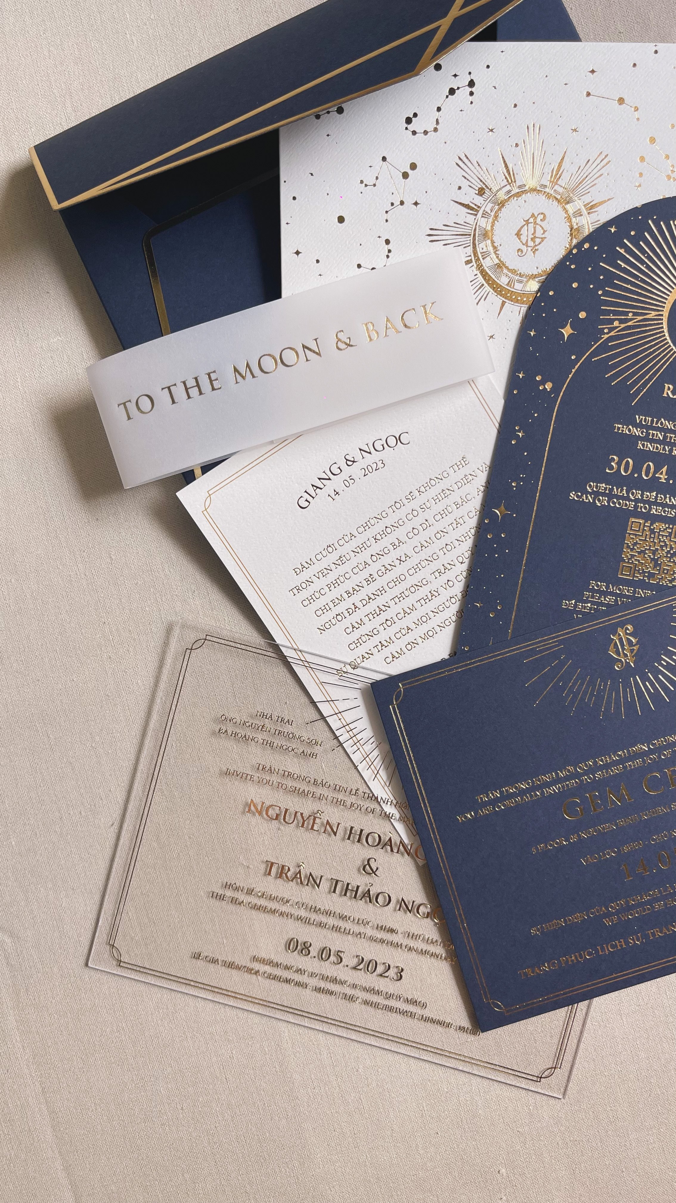 Elegant wedding invitation suite in navy blue and white with gold accents, including a main invitation card, RSVP card, and a box for the invitations.