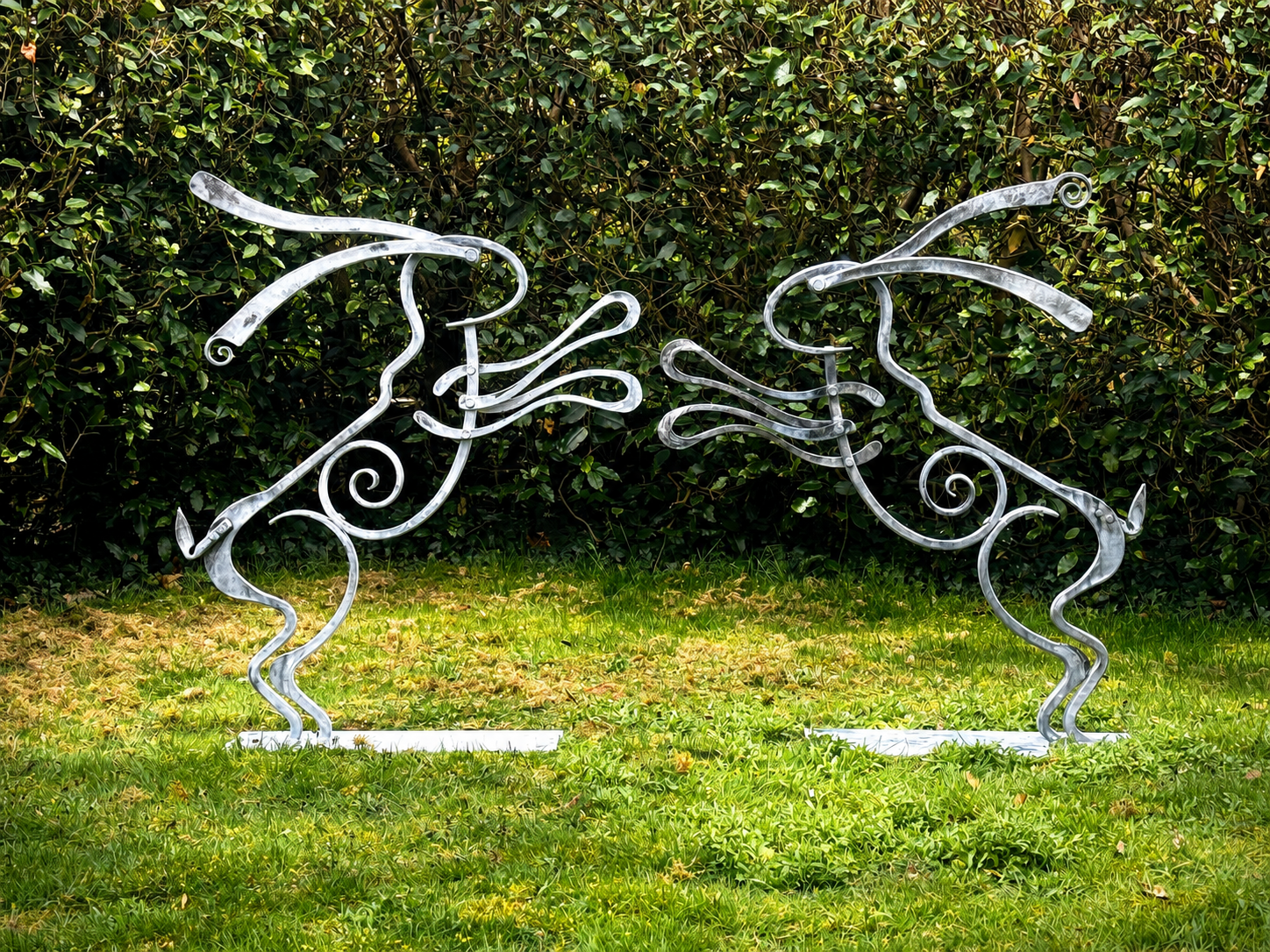 hand forged boxing hares steel sculpture by kit garnett at a sculpture park