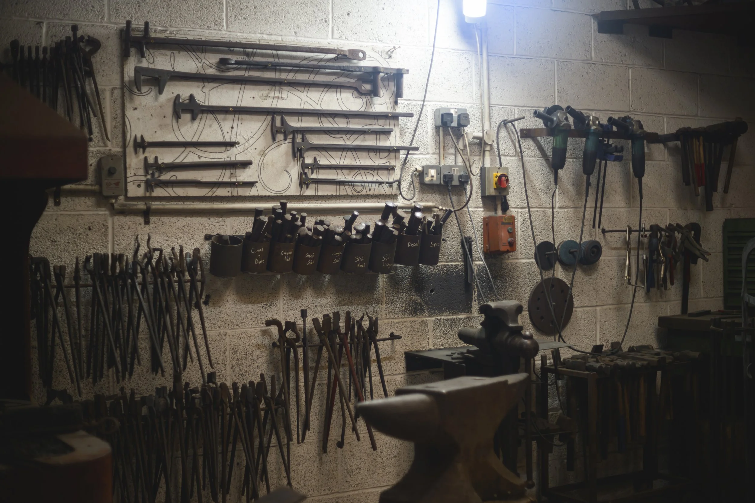 the wall of the forge with all the tongs and punches