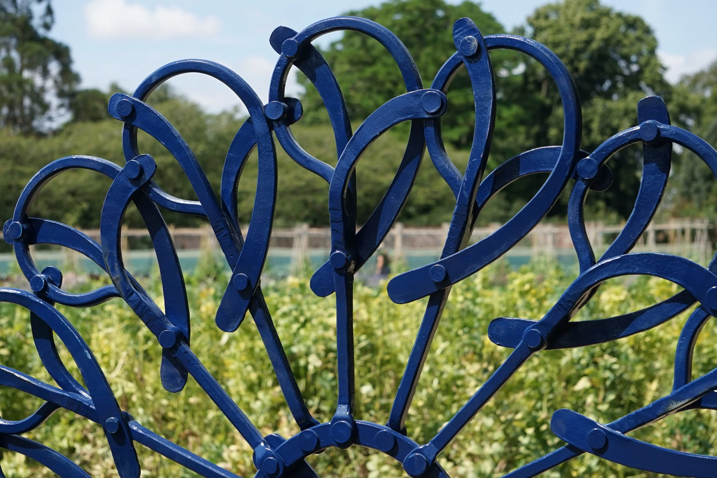 Close-up of a blue decorative metal garden sculpture divergence - one of kit garnetts forged sculptures
