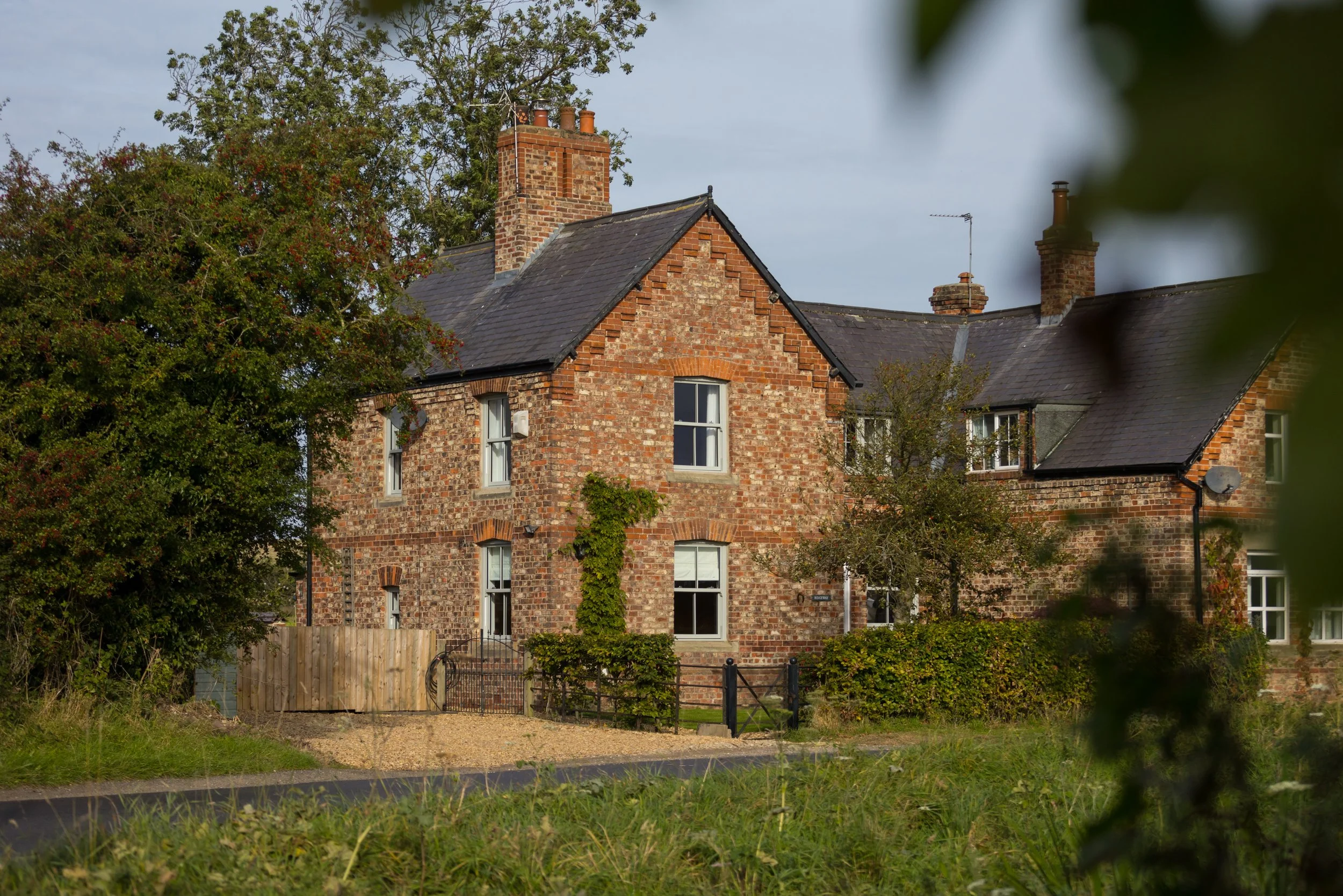 brick cottage with out of focus foliage in foreground