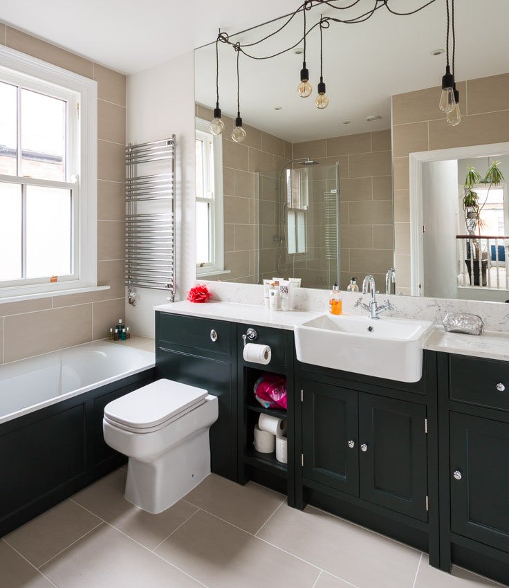  slightly tidier of the same modern green and white bathroom as above with minimal products on the counter 