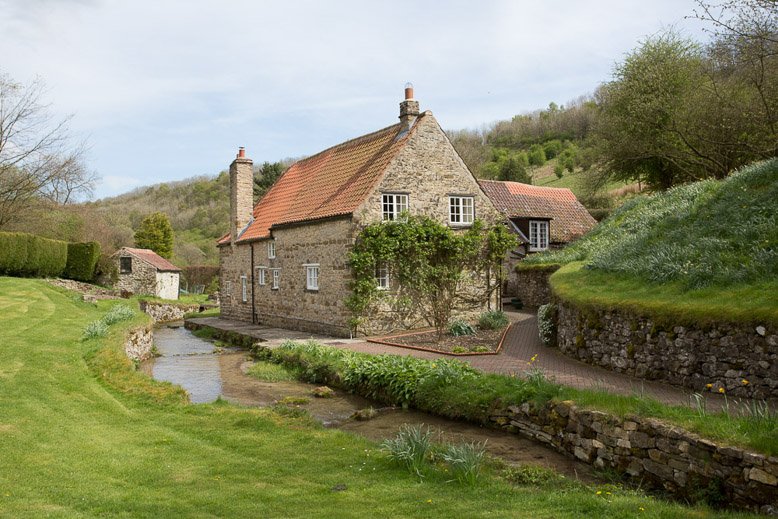  head height of image countryside cottage with river alongside  