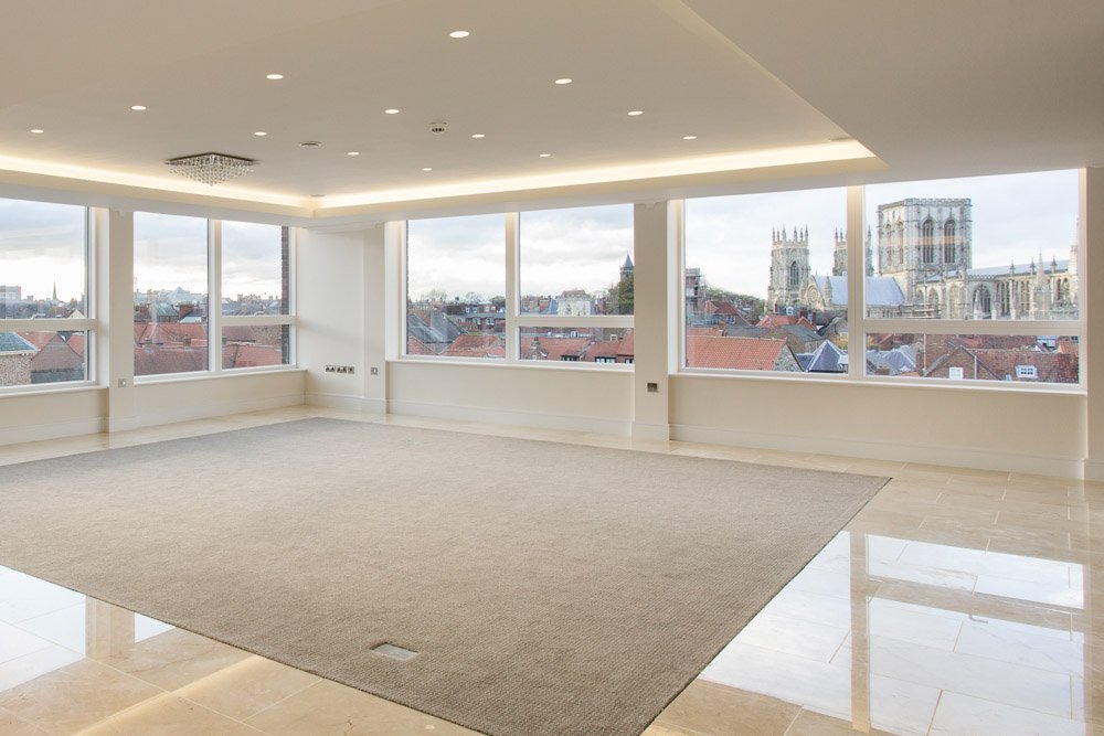  empty modern apartment part tile part carpet floor with panoramic windows overlooking York city centre and the minster  