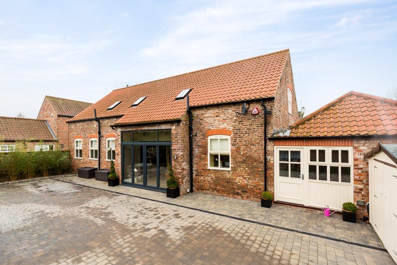  head height image of large barn conversion from inside courtyard walls 