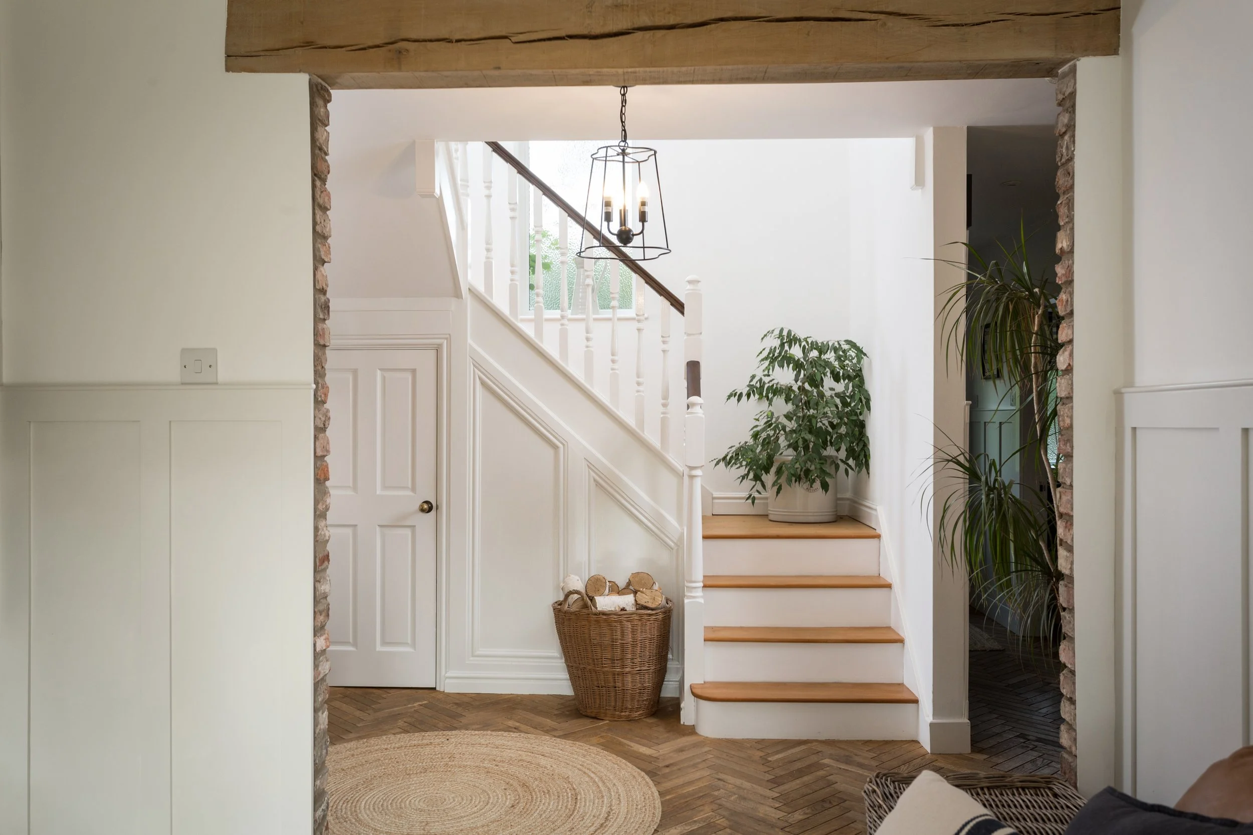wooden staircase with mini half landing with a houseplant, wooden wishbone flooring