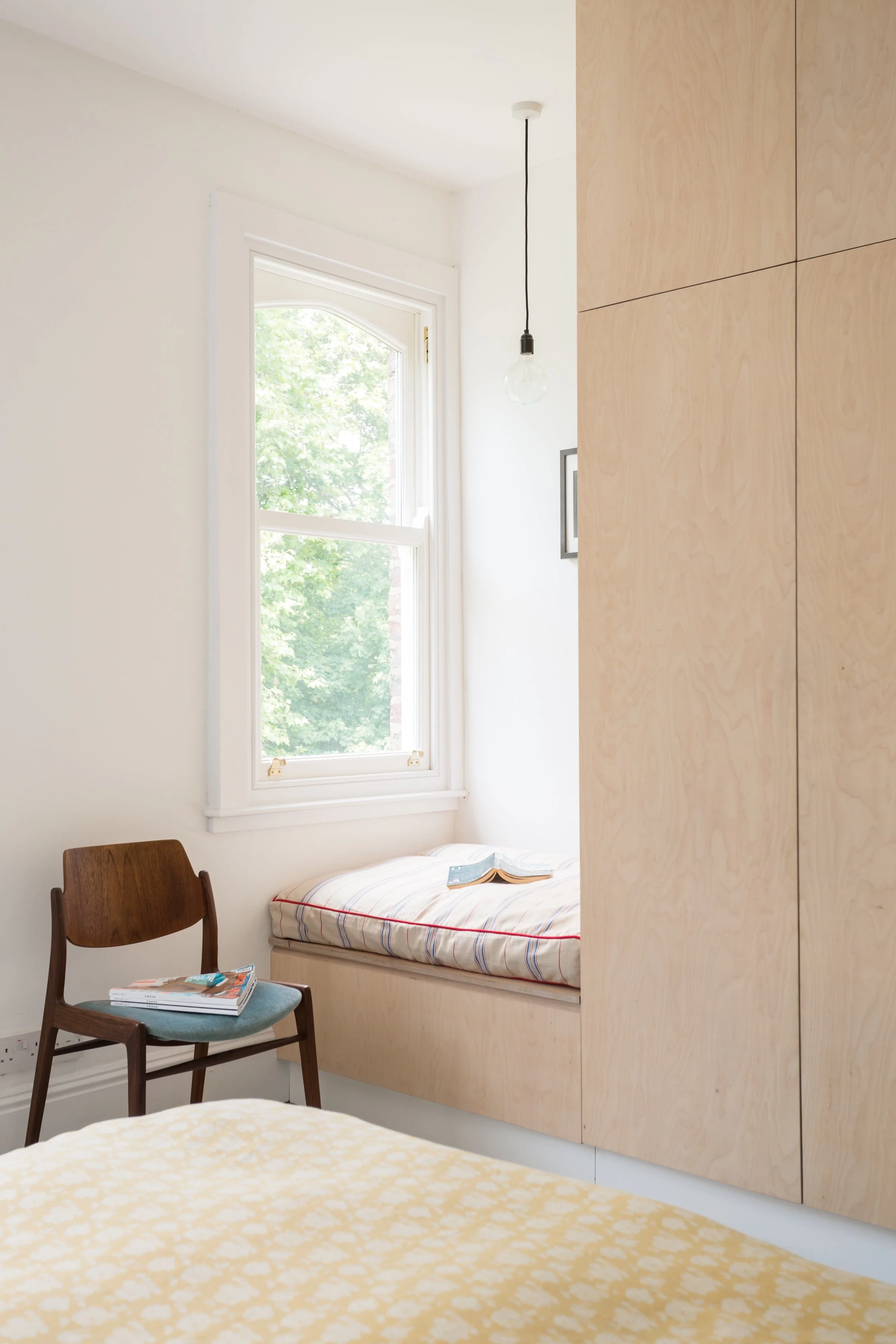 lifestyle image of window seat with small mid century wooden chair