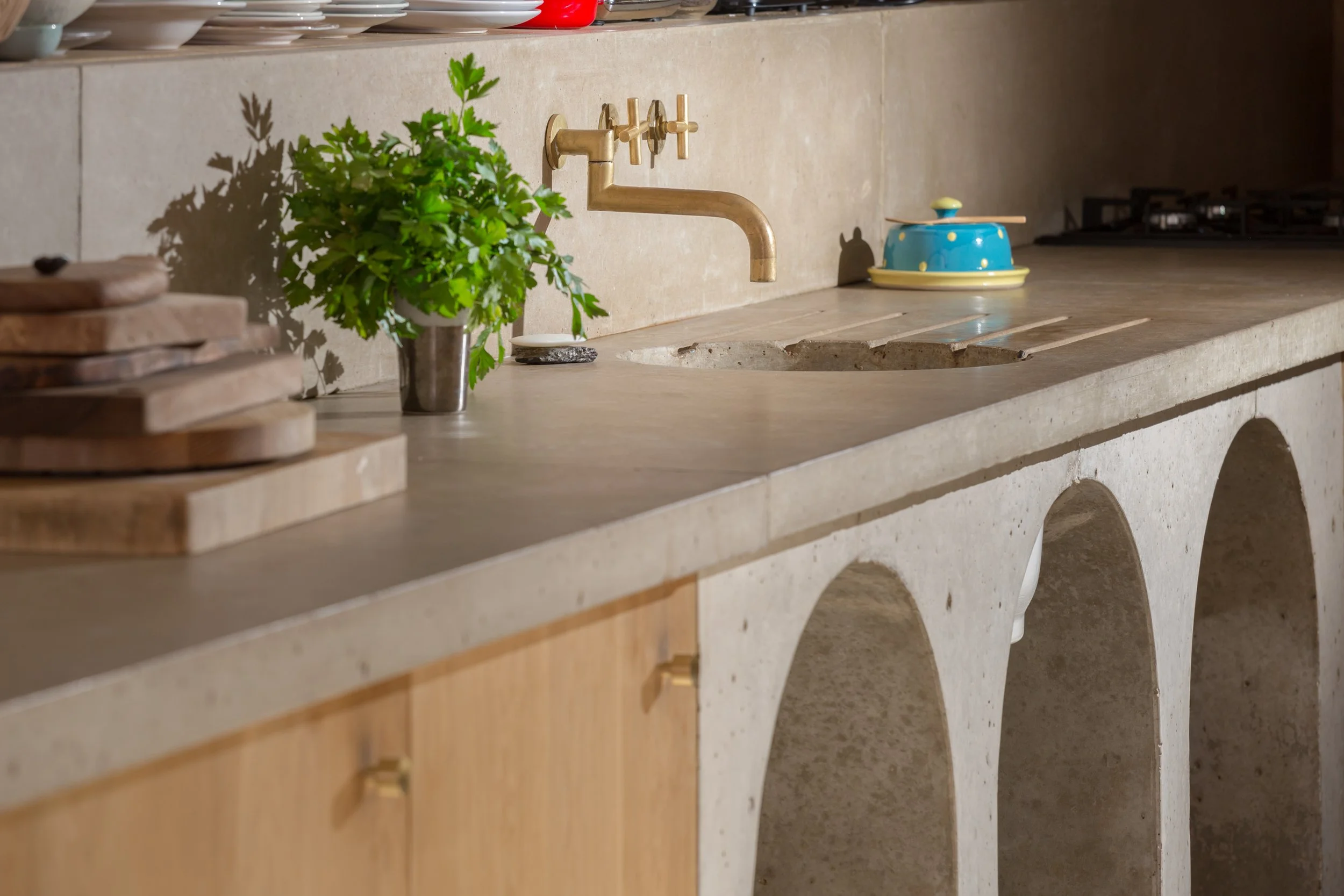 detail shot of concrete kitchen top and brushed brass tap