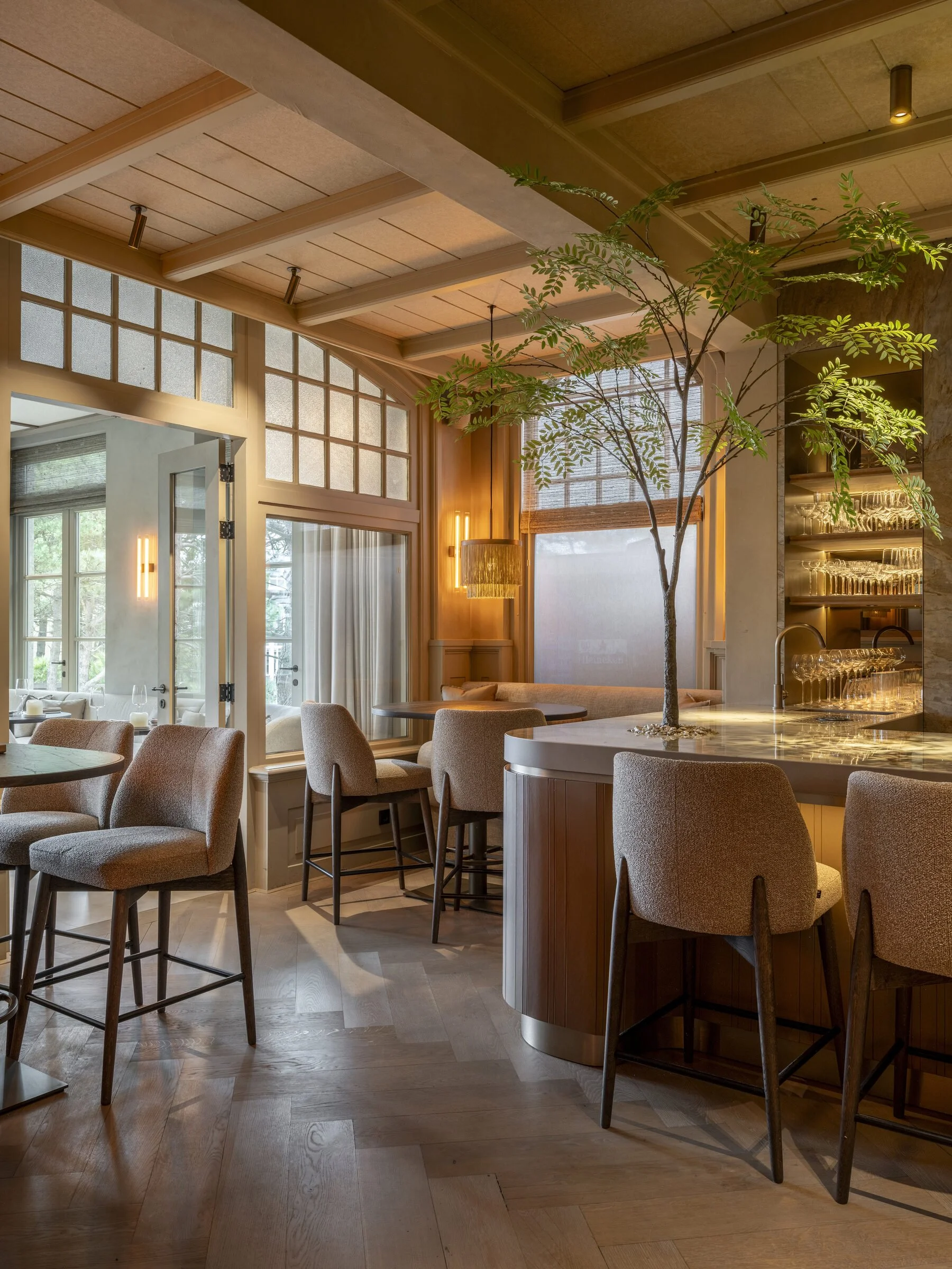 The cocktail bar of Lumé with bar stools and warm brass lighting