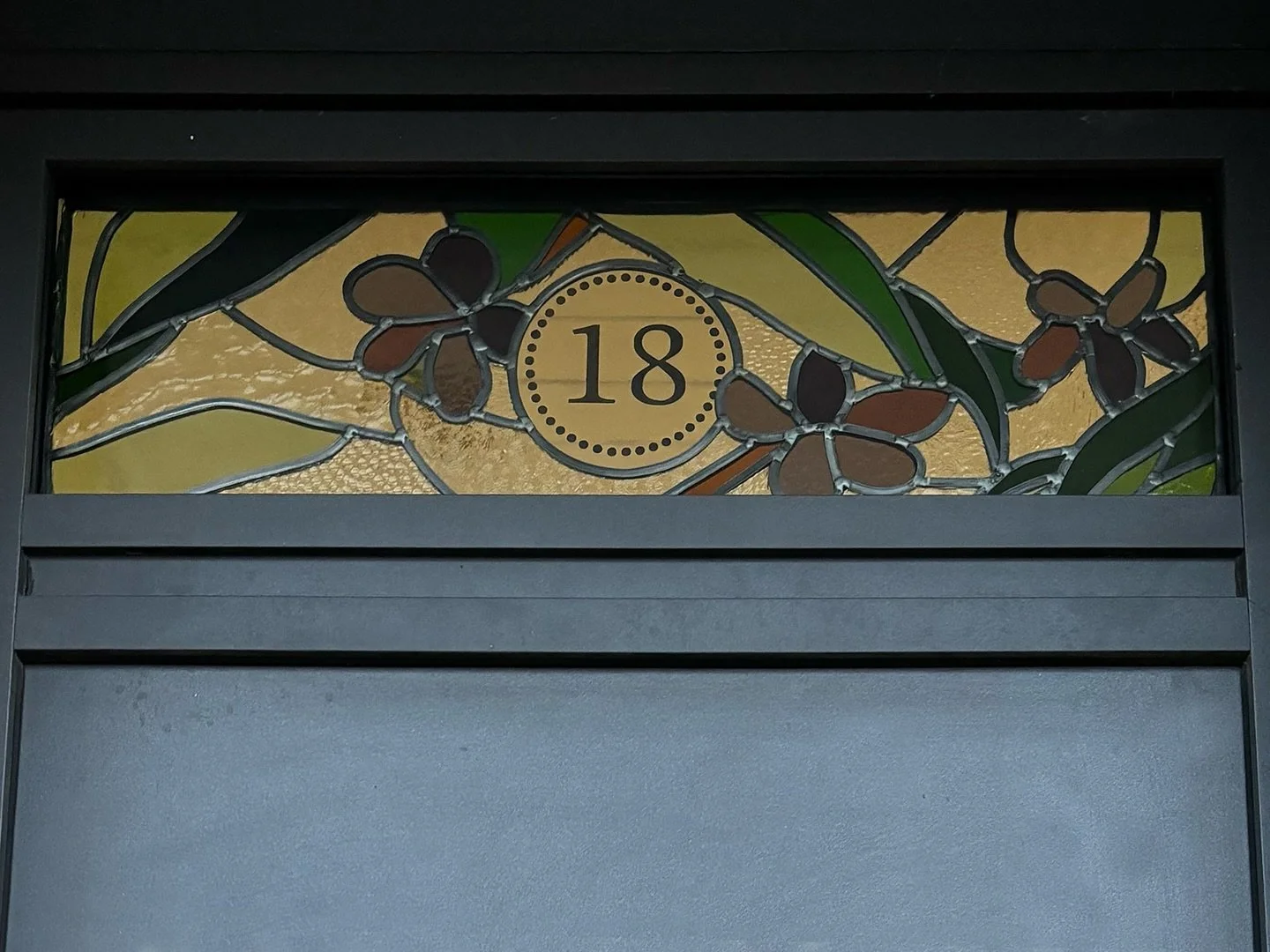 Des verres textur&eacute;s, des roses pourpres, une verdure dense, des couleurs chaudes pour accueillir.
A l&rsquo;entr&eacute;e de cette maisonnette pr&egrave;s de Toulouse, un motif floral pour cette imposte.  Dehors le dessin s&rsquo;annonce, deda