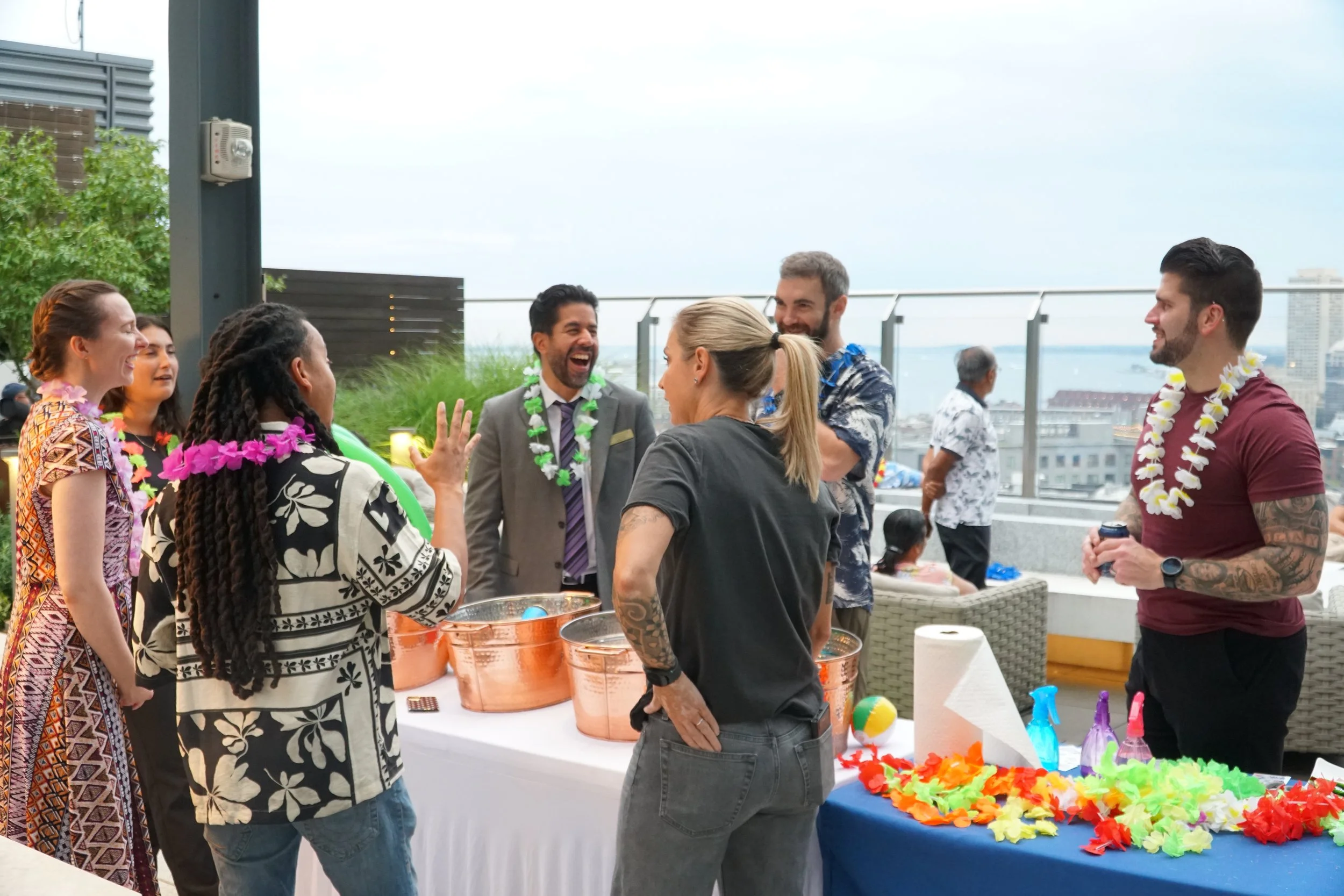 Residents socializing during an Aloha Night rooftop event in Boston