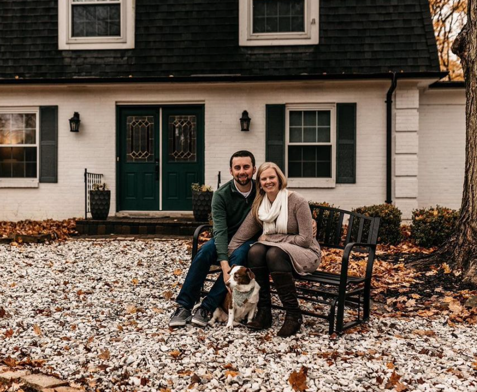 A couple and their dog sit on a bench in front of their home in Blue Ash, Ohio