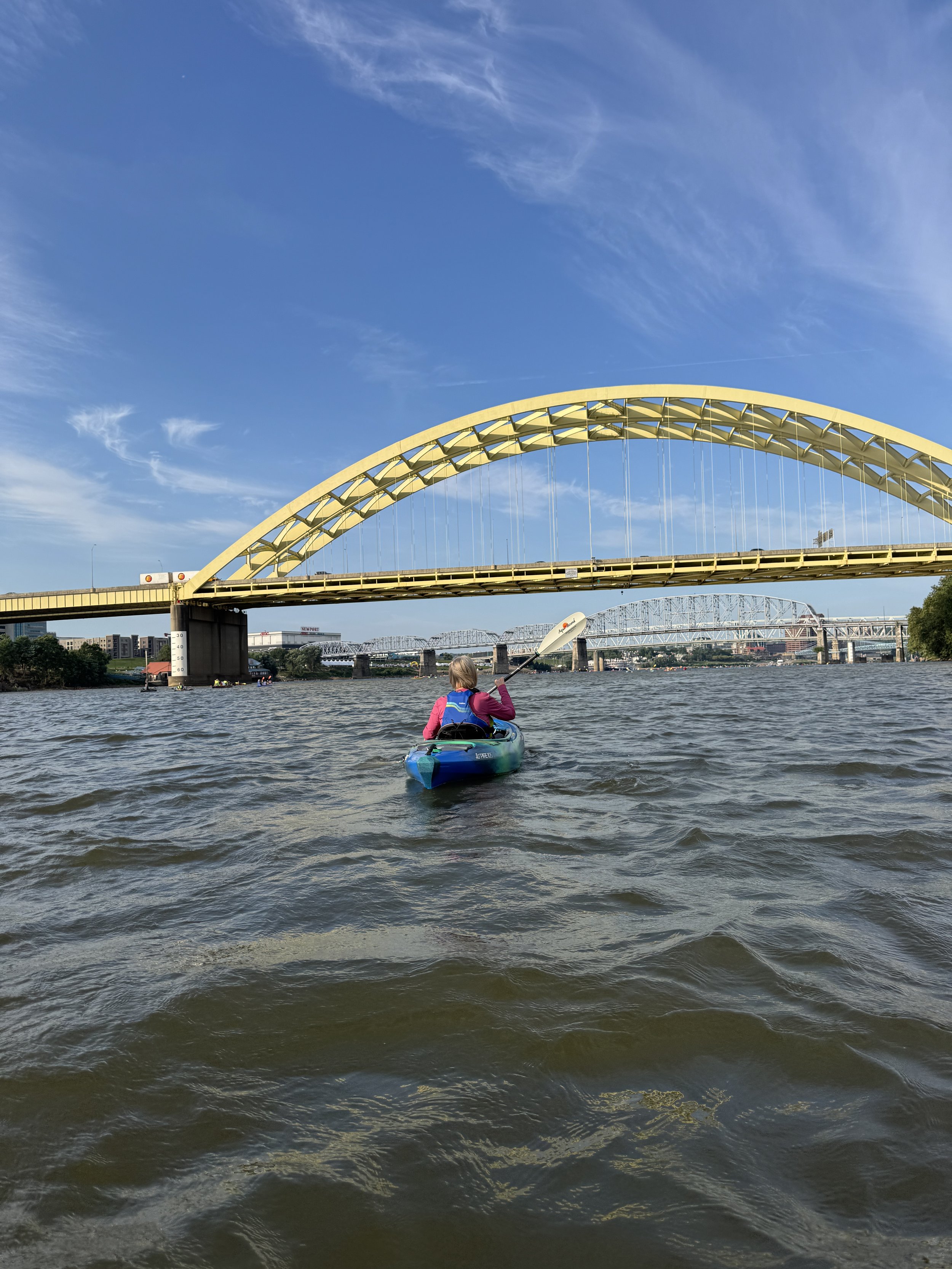 Kayaker and bridges on Ohio River between Ohio and Kentucky