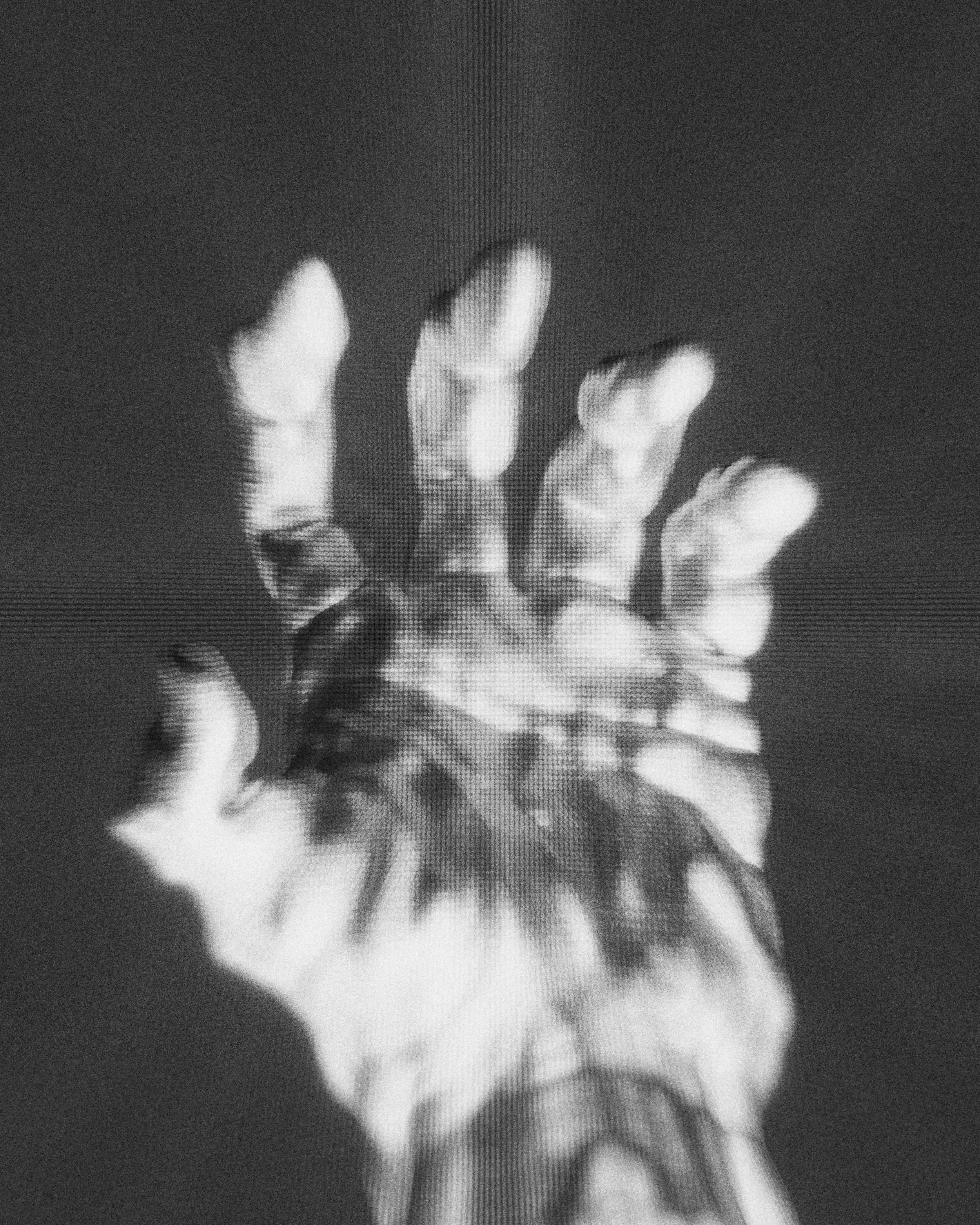 Een zwart-wit foto van een uitgestoken hand met vijf vingers gericht naar de camera.