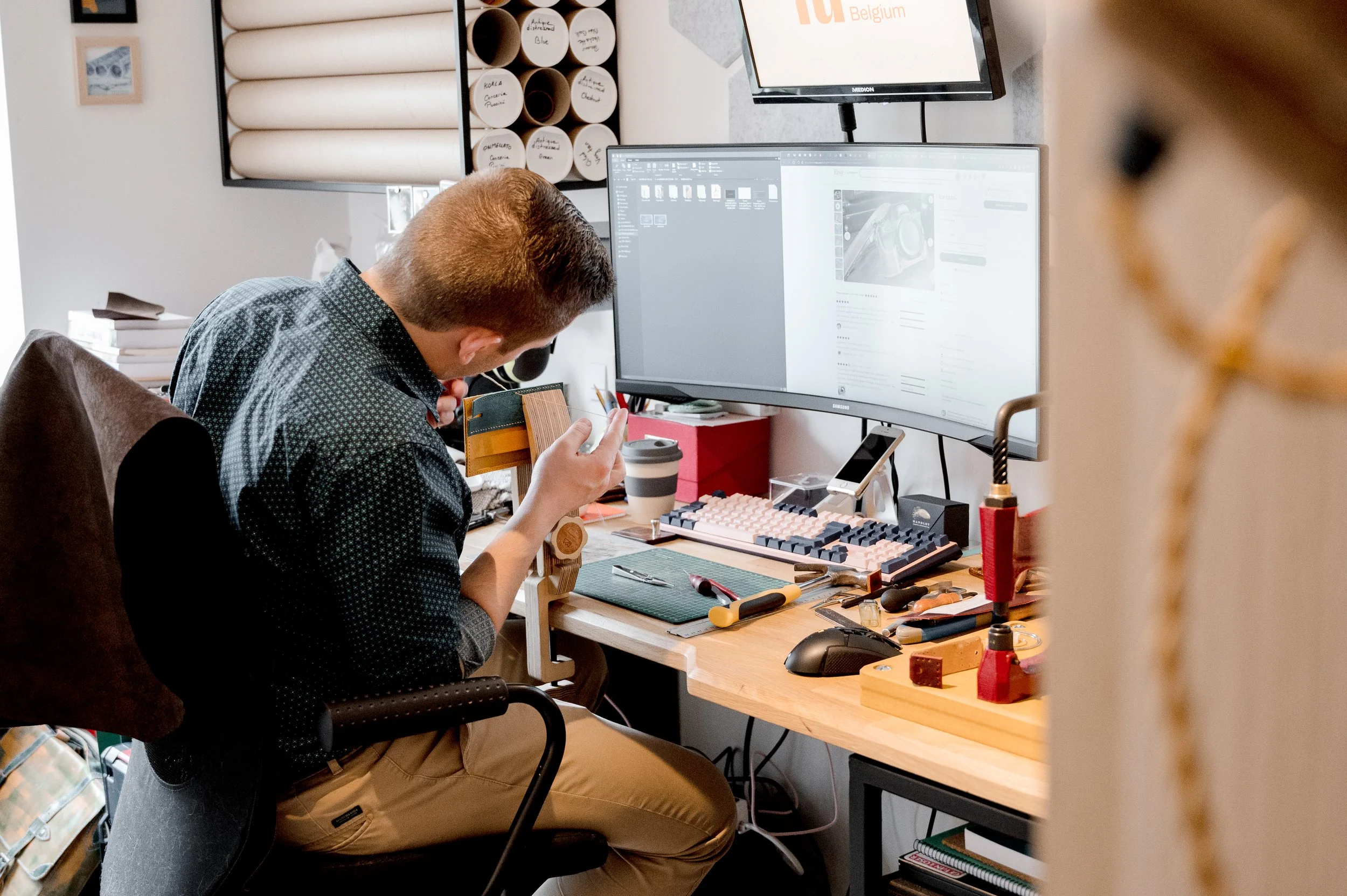 Emmanuel, l'artisan maroquinier, travaillant dans son atelier sur un prototype