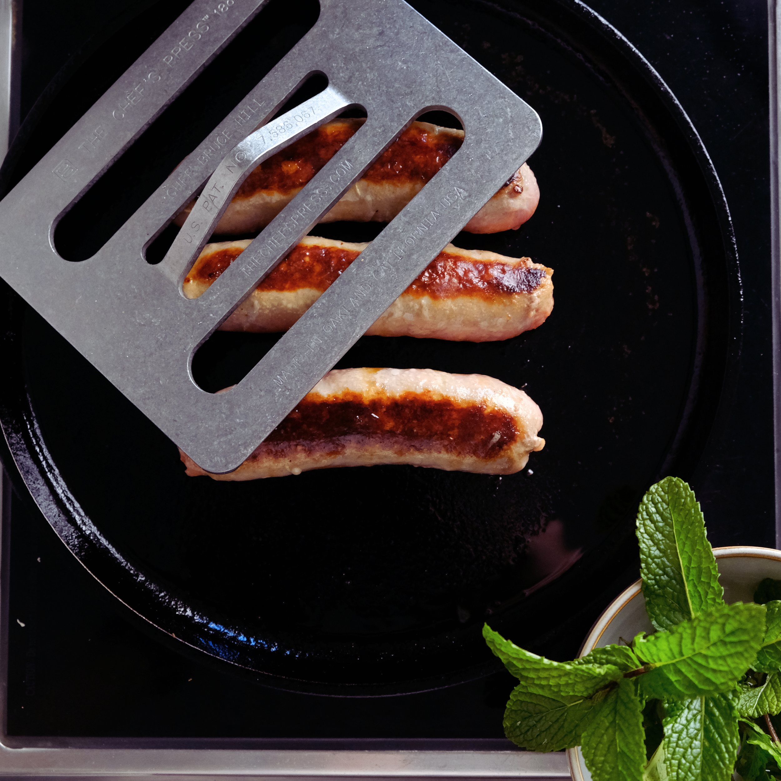 cooked spicy sausage with chef's press.png