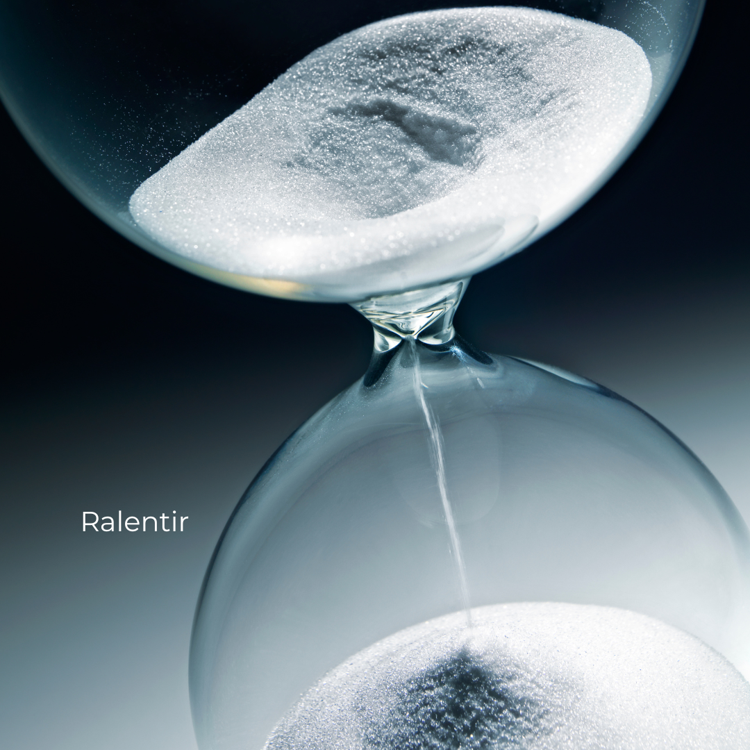 Un sablier en verre avec du sable blanc qui coule d'une partie à l'autre, symbolisant le ralentissement du temps.