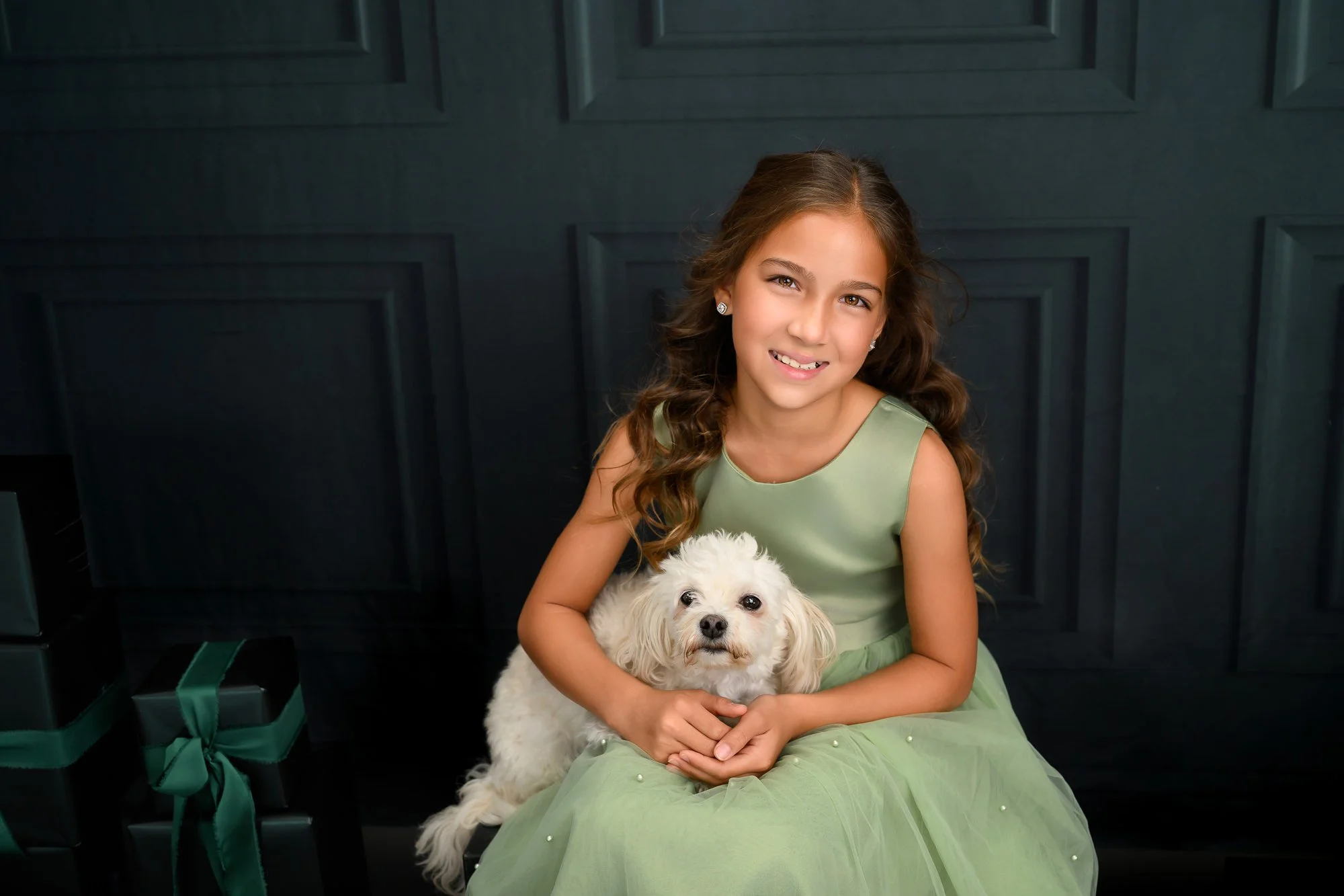Holiday-themed photo session advertisement featuring a young girl in a gold dress, holding a toy soldier, with holiday decorations; dates include October 25-26 and November 9, 2024.