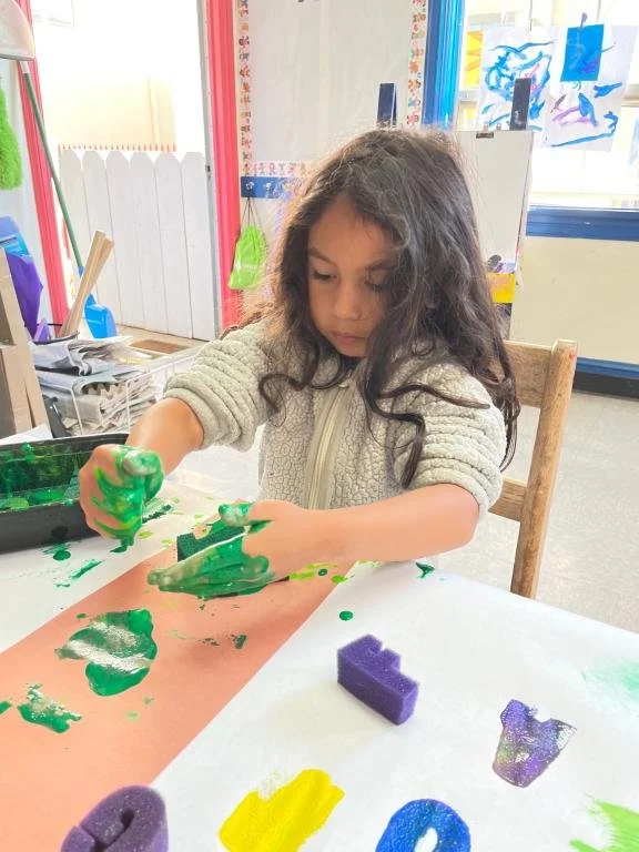 A preschool student painting during an art activity