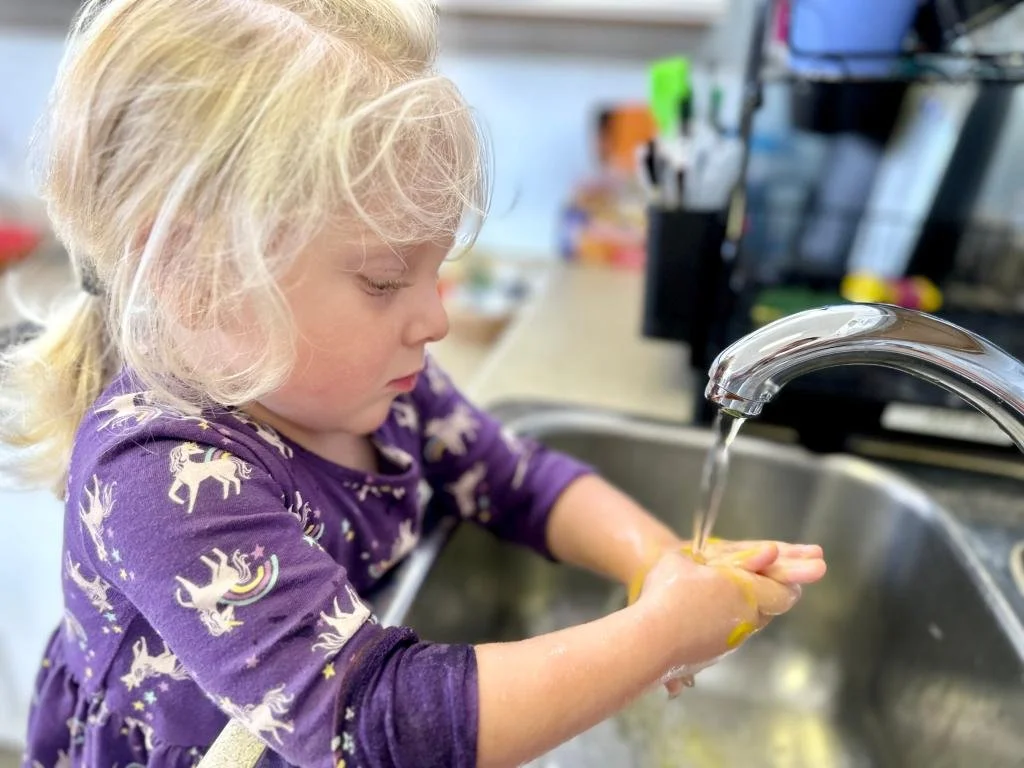 A preschool child washing hands independently