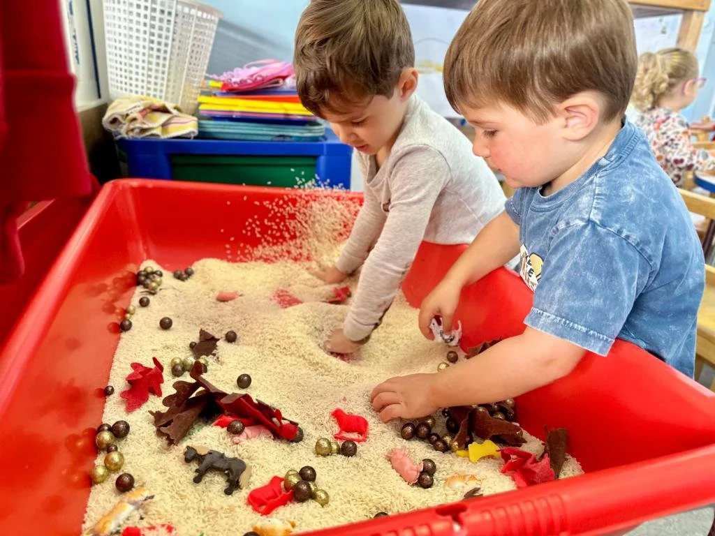 Toddlers exploring a sensory table