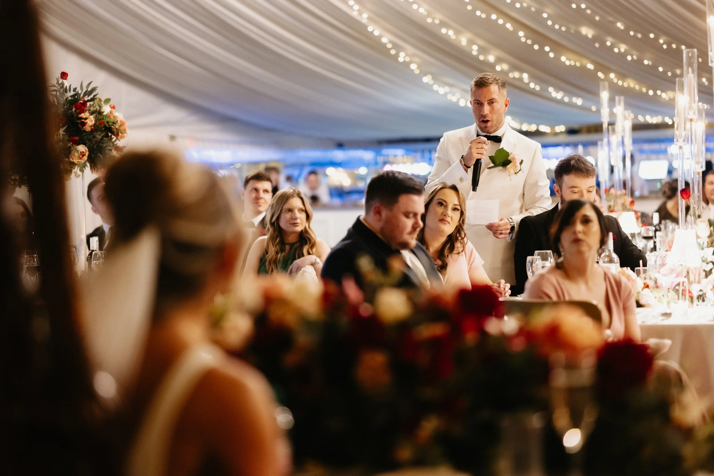 Grooms wedding speech taking place during the winter wedding breakfast at Netley Hall, with guests listening and reacting around the room.