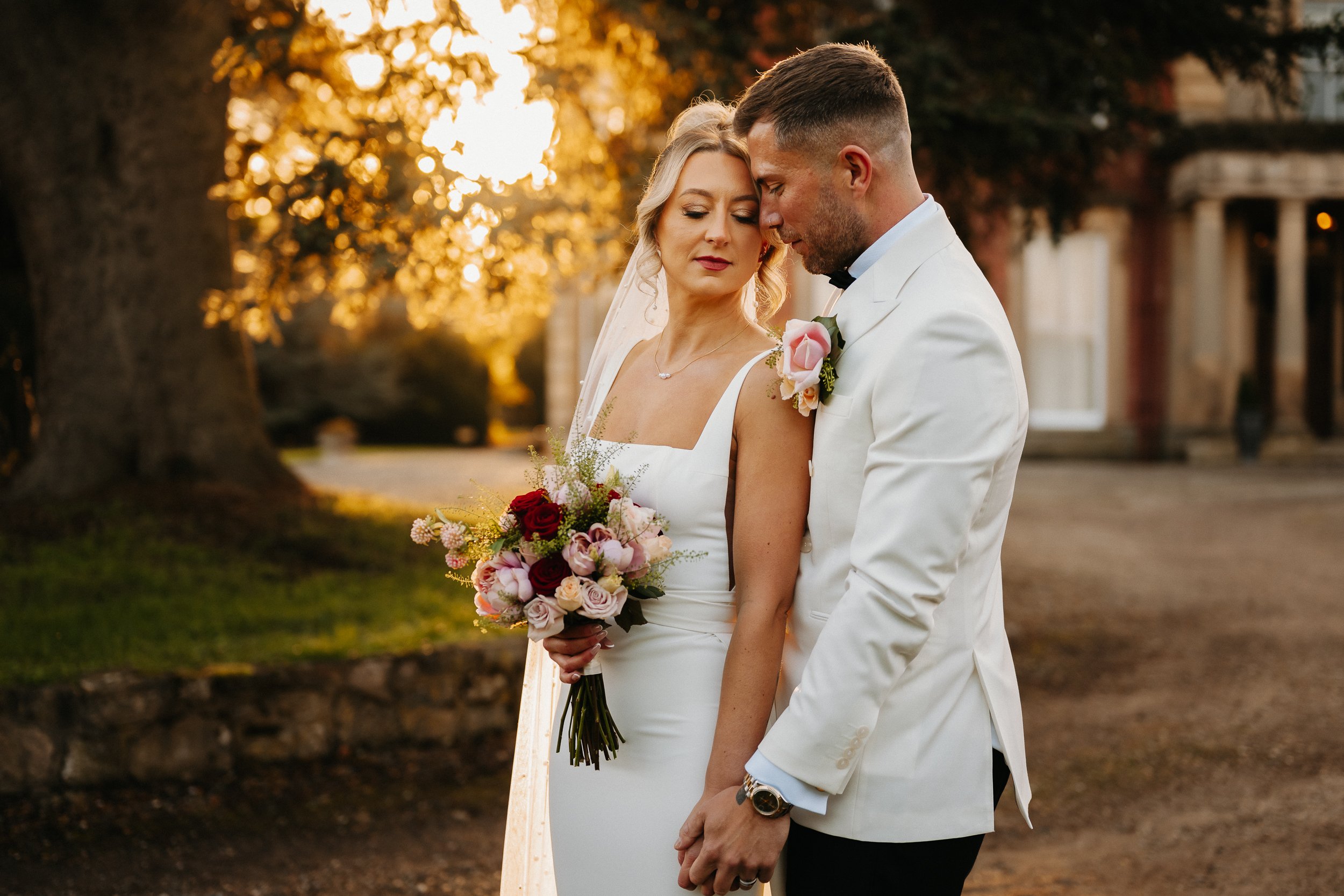 Bride and groom in white at Netley Hall during winter golden hour