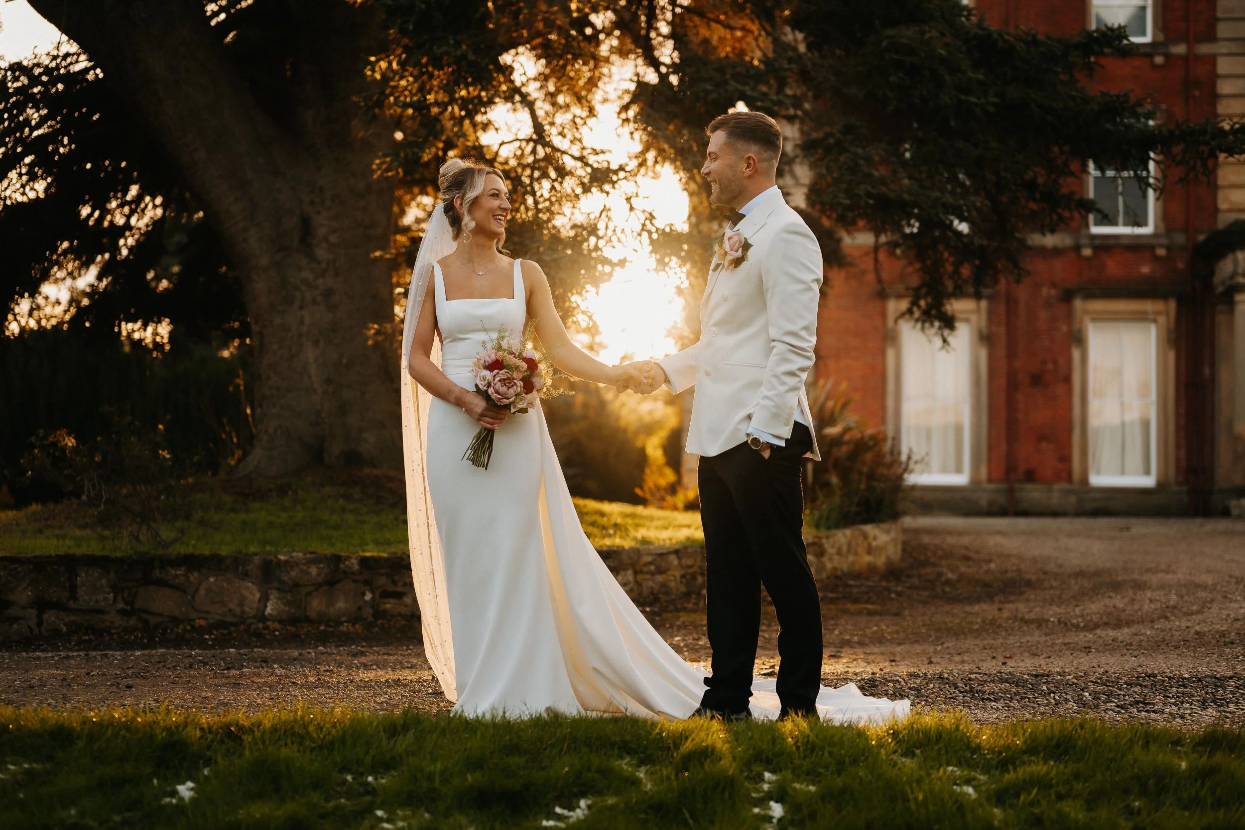 Bride and groom in white at Netley Hall during winter golden hour