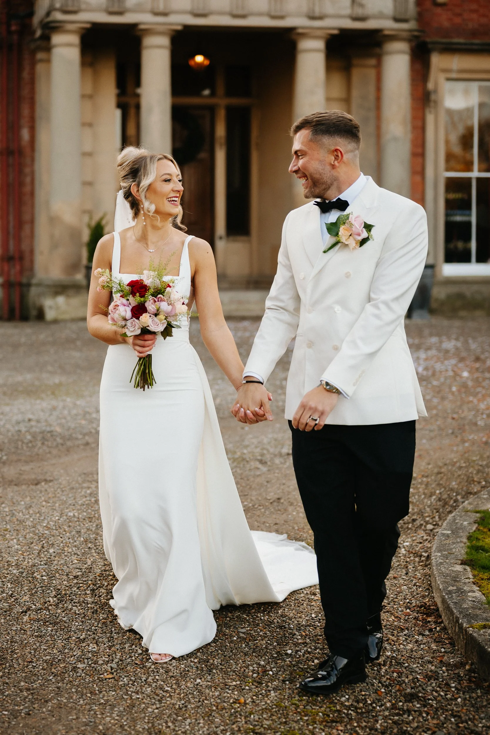 Bride and groom in white at Netley Hall during winter golden hour