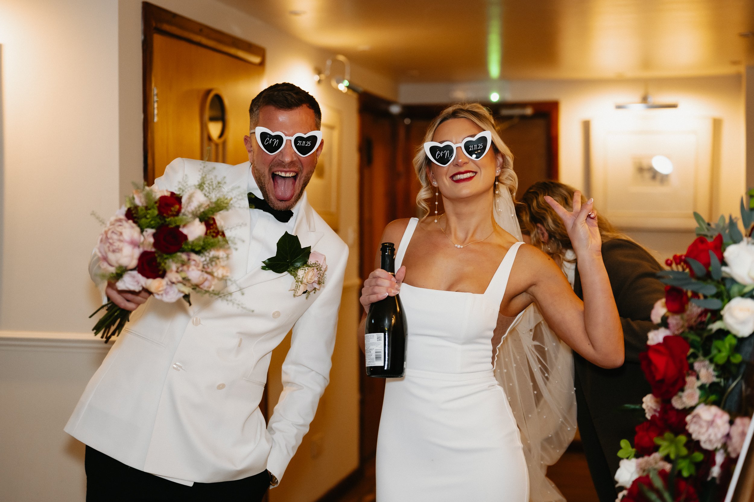 Bride and groom making a bold entrance wearing sunglasses into their wedding breakfast at Netley Hall during their winter wedding reception.
