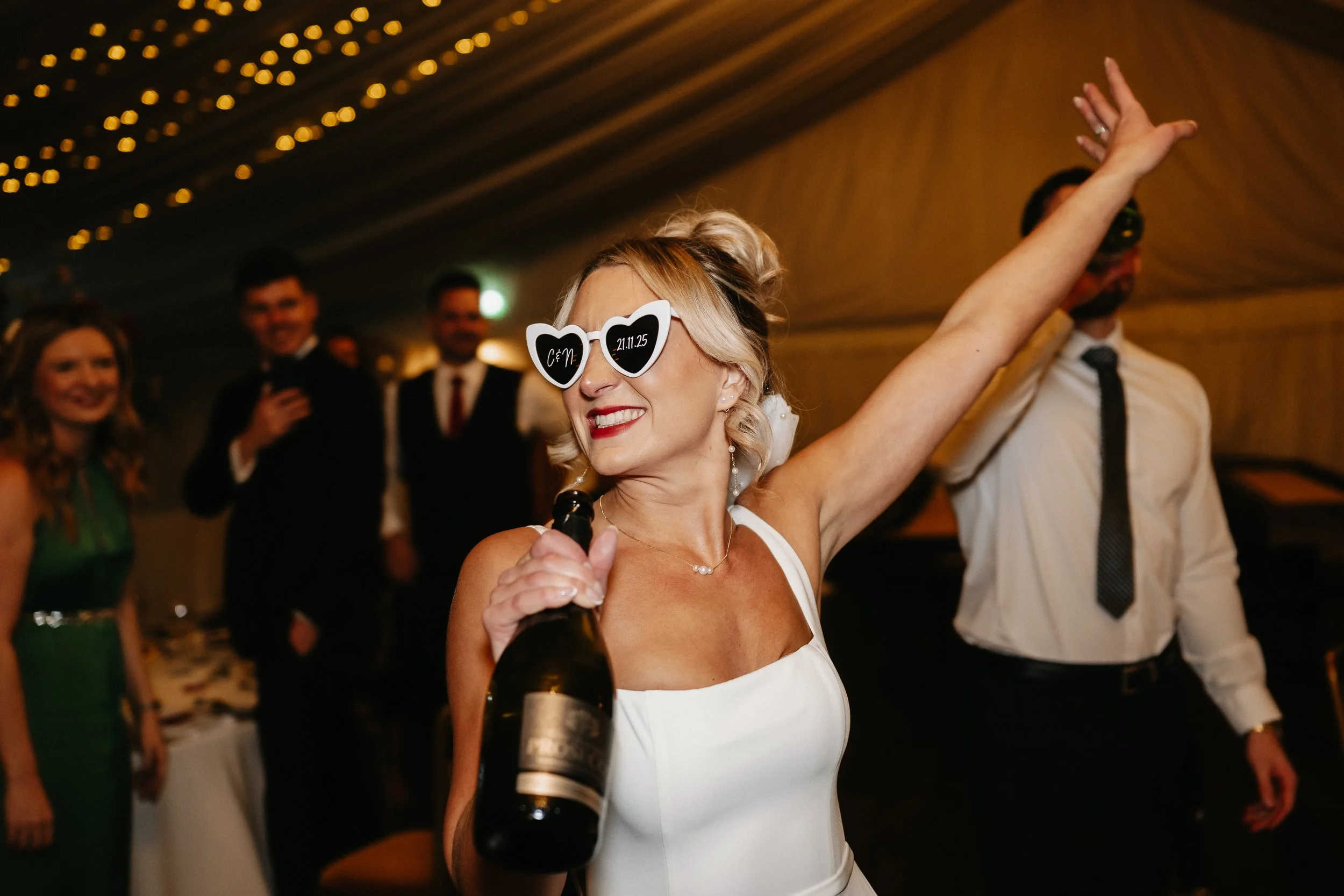 Bride and groom making a bold entrance wearing sunglasses into their wedding breakfast at Netley Hall during their winter wedding reception.