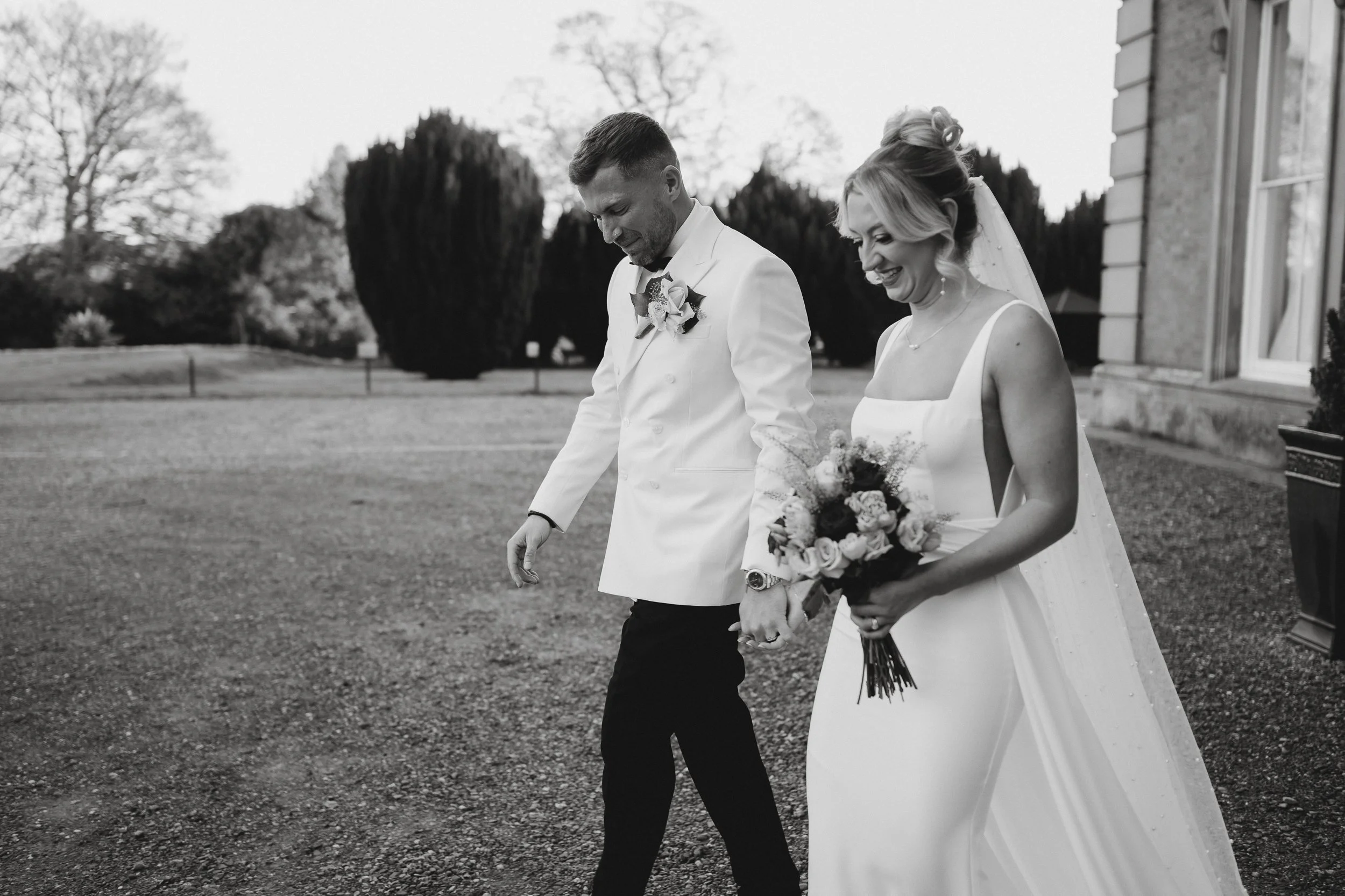 Bride and groom walking back down the aisle at Netley Hall after their winter wedding ceremony, smiling and celebrating as guests cheer around them.