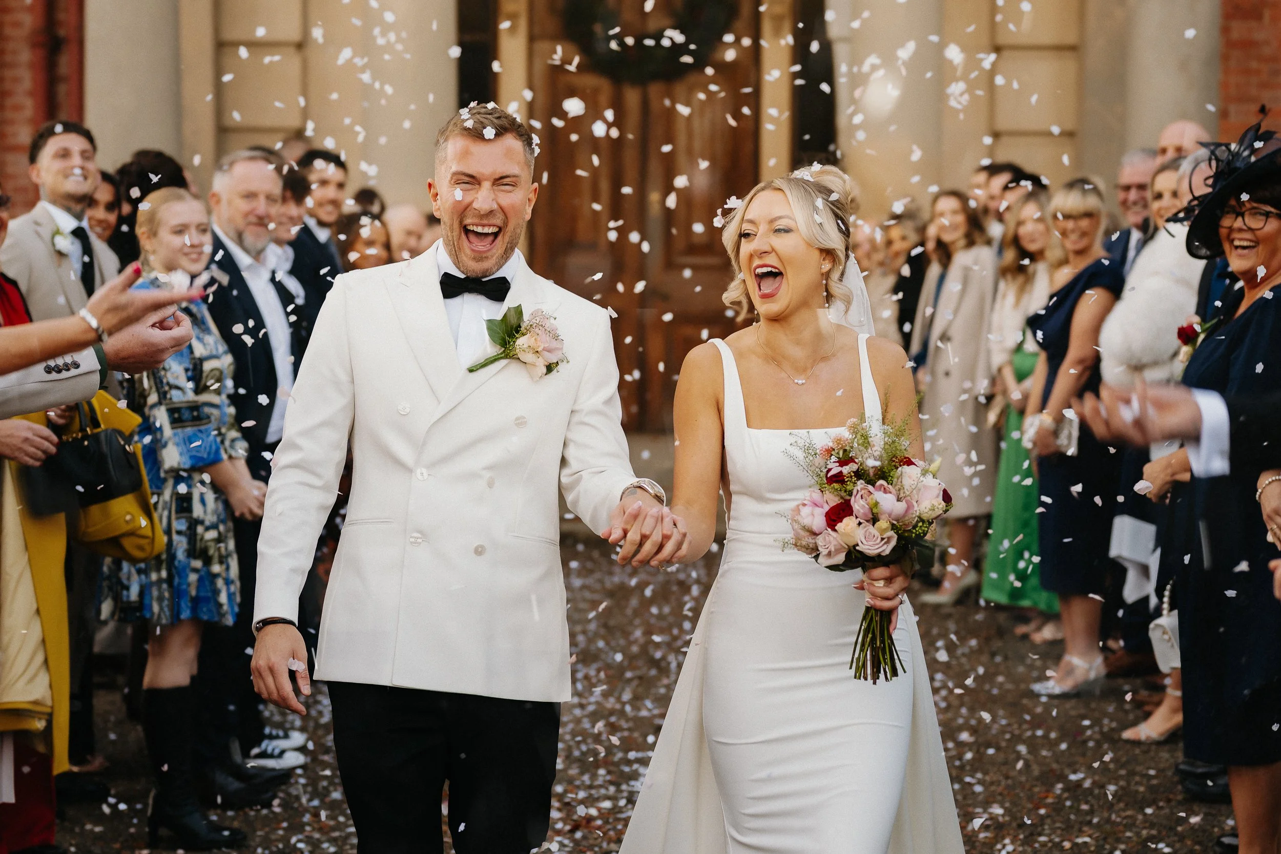 Bride and groom confetti exit at Netley Hall wedding venue in Shropshire
