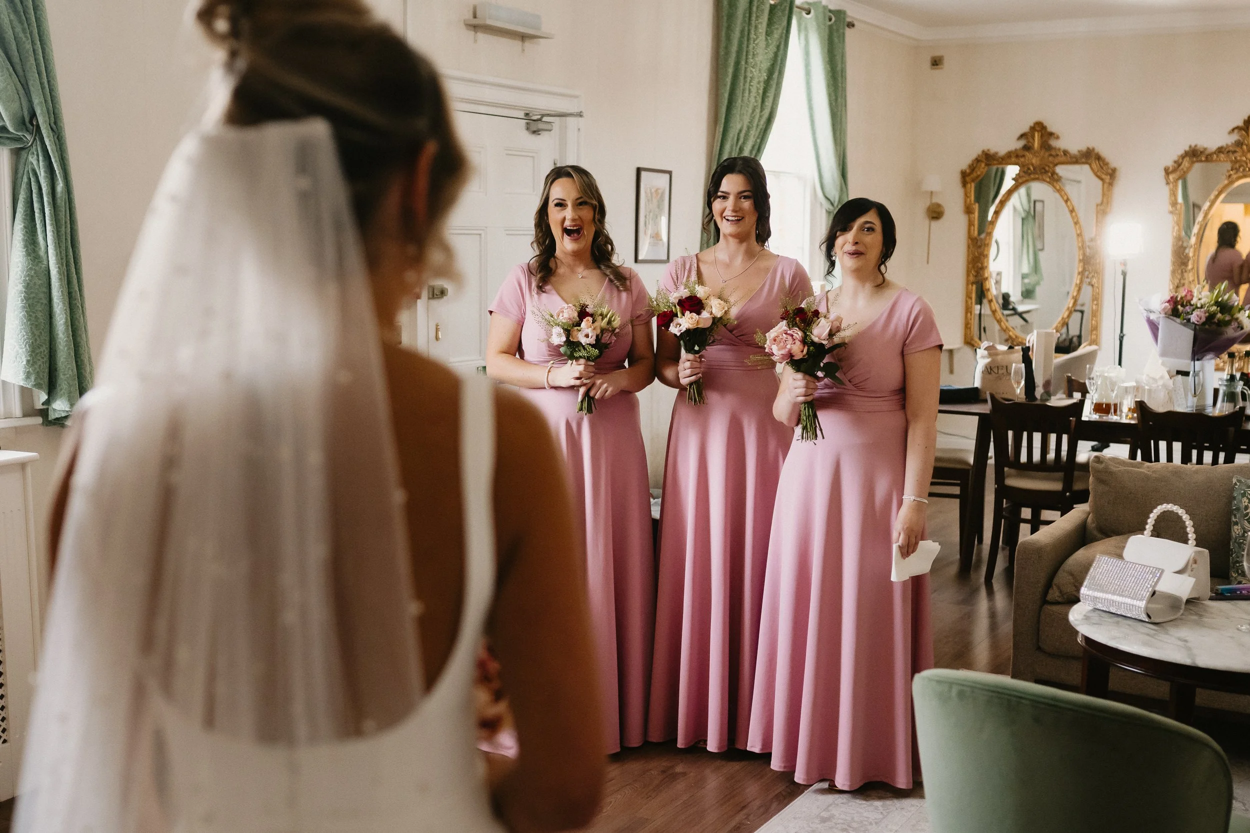 Bride reveal to bridesmaids at Netley Hall during a winter wedding morning