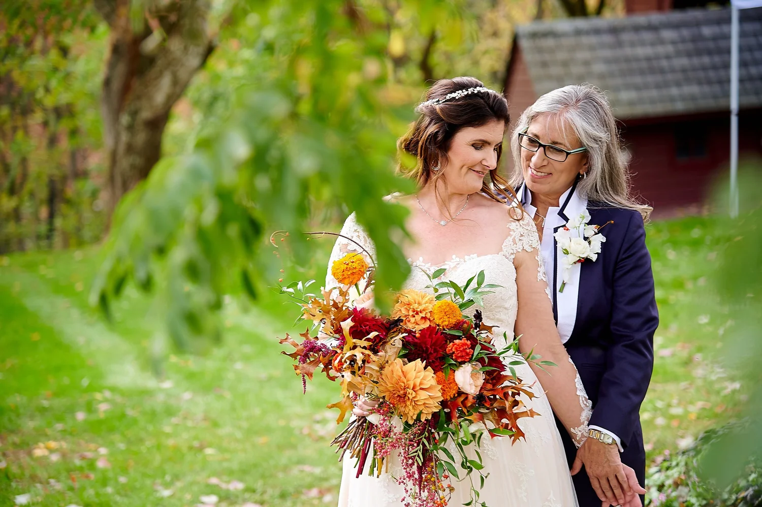 Bride with an autumn bouquet near a red barn at a farm and garden wedding