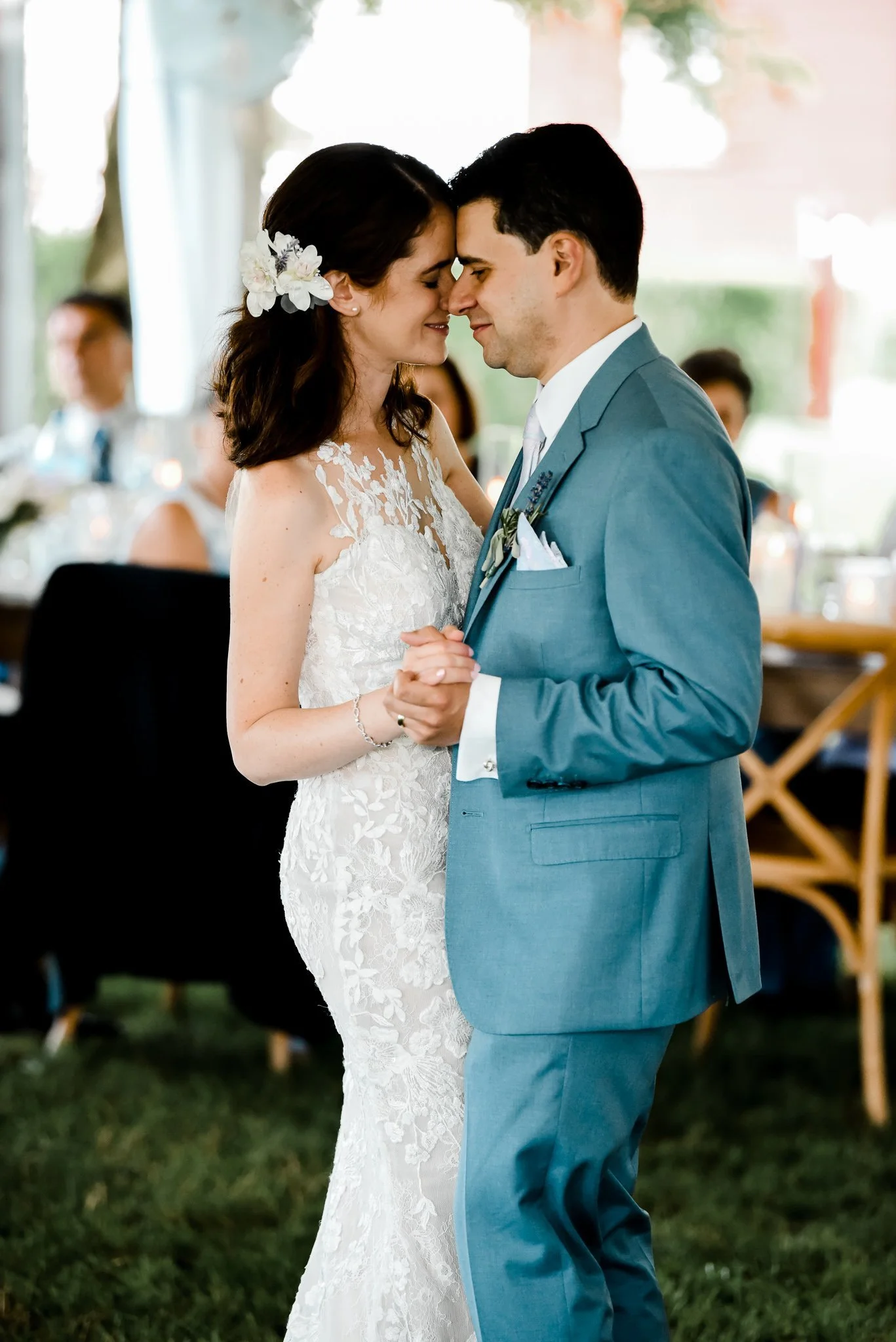 Bride and groom slow dancing under a tent