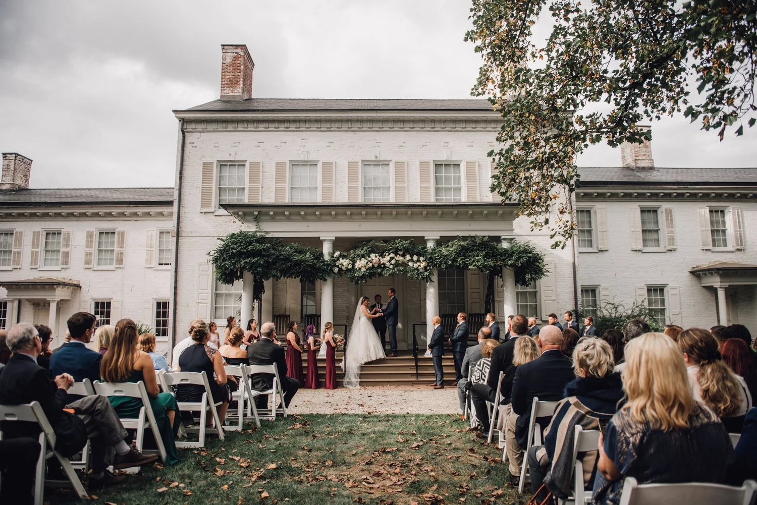 Outdoor wedding ceremony with guests seated on the lawn