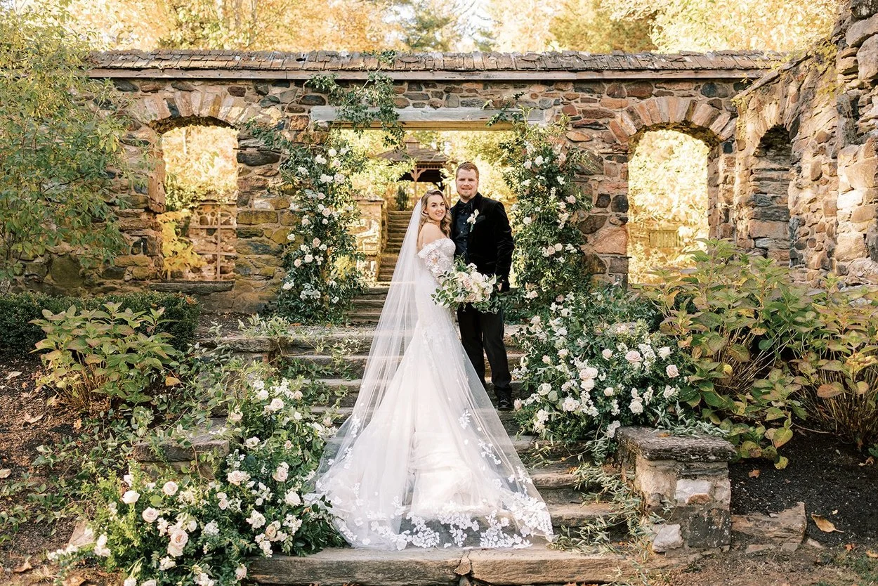 Bride and groom in a garden stone archway