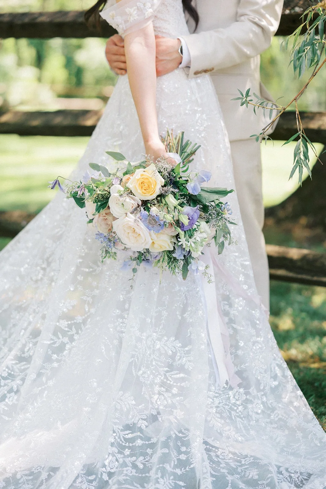 Bride's pastel bouquet against her lace gown