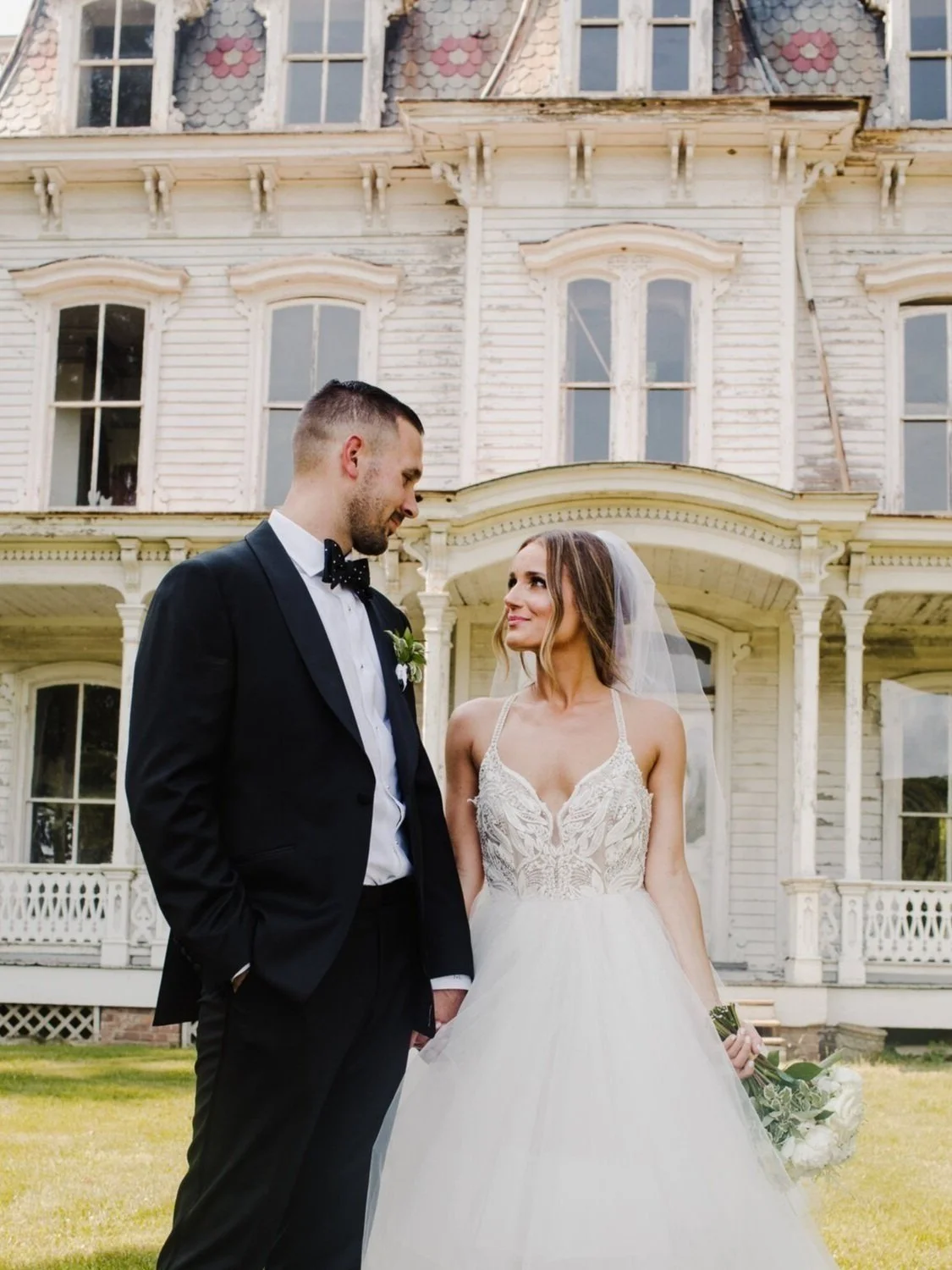 Bride and groom on the lawn of a Victorian mansion at a historic landmark wedding