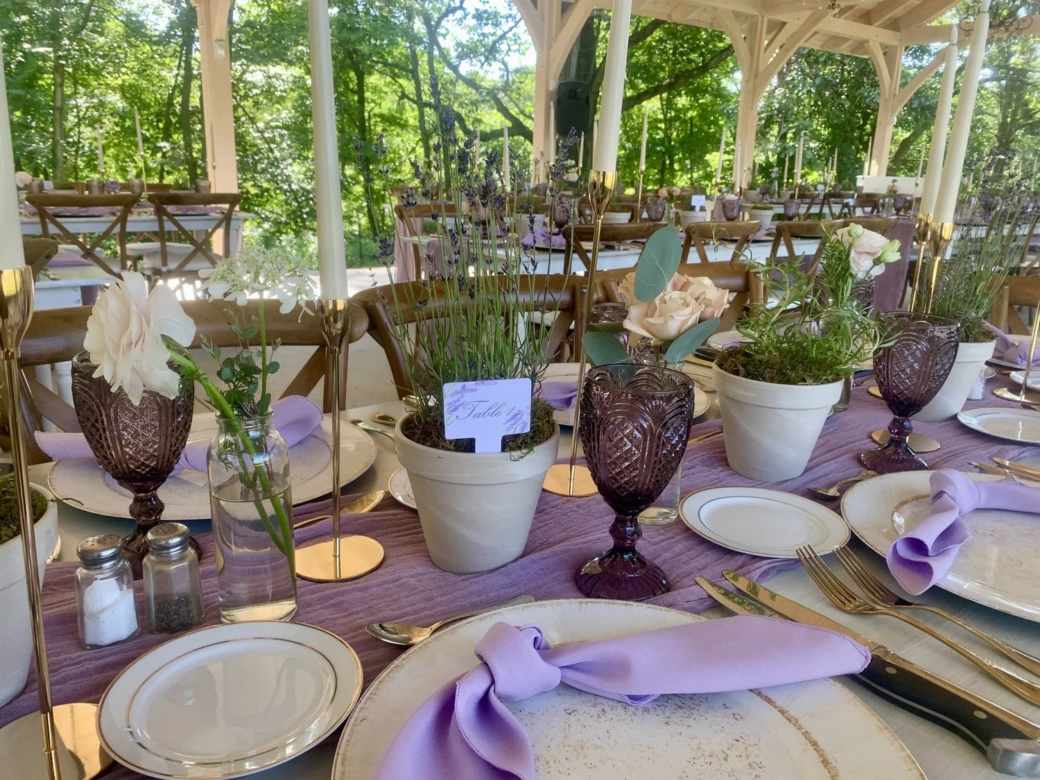 Lavender and blush rose tablescape under a wooden pavilion