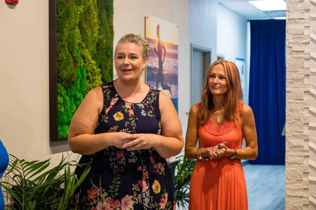 Two hosts welcoming guests at a grand opening
