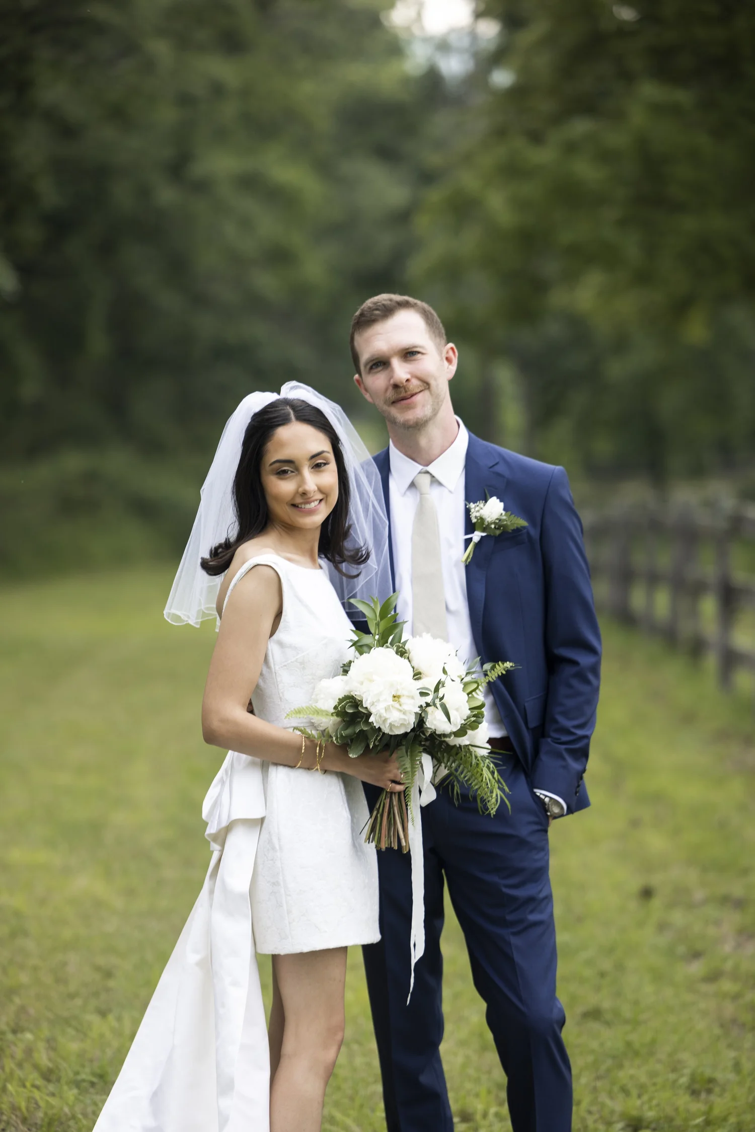 Bride and groom on a tree-lined lane at a private estate wedding