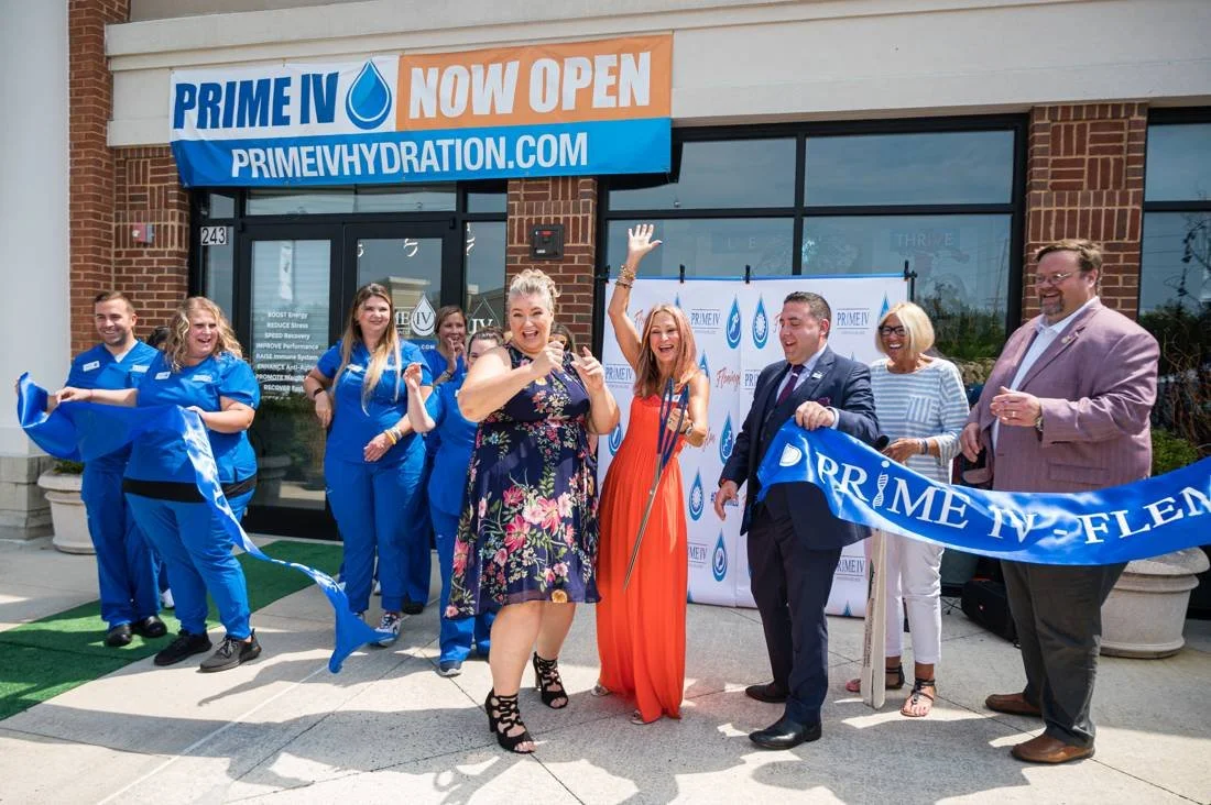 Ribbon falling as a grand opening crowd cheers outside the new storefront